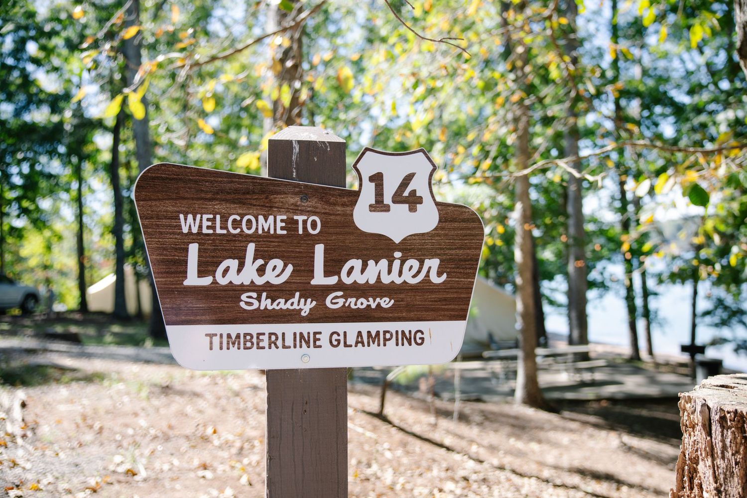 Welcome to Lake Lanier Shady Grove sign at Timberline Glamping site 14, surrounded by trees.
