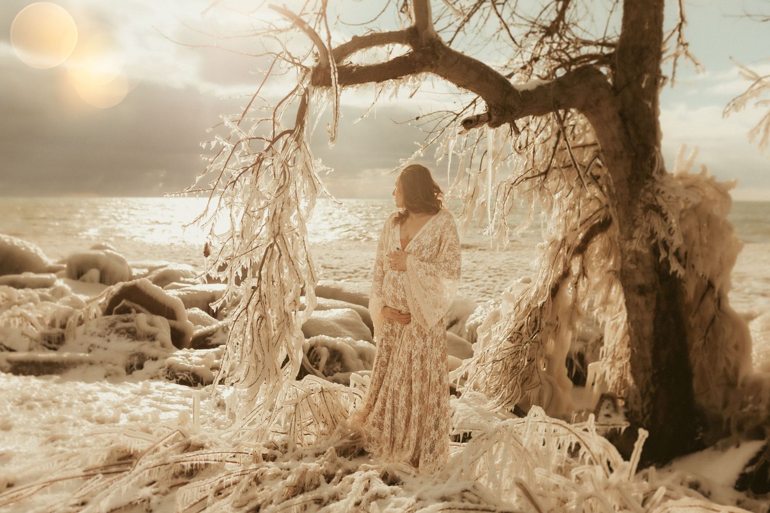 Stunning maternity session at the beach in winter coated with shimmering ice and golden sunlight by Bowmanville, ON family photographer.
