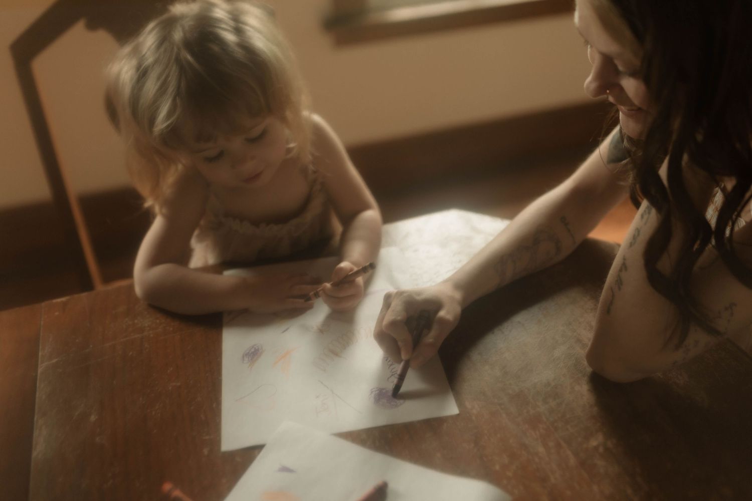 Mom and daughter colouring together at the kitchen table by Oshawa Family Photographer at an in home session.