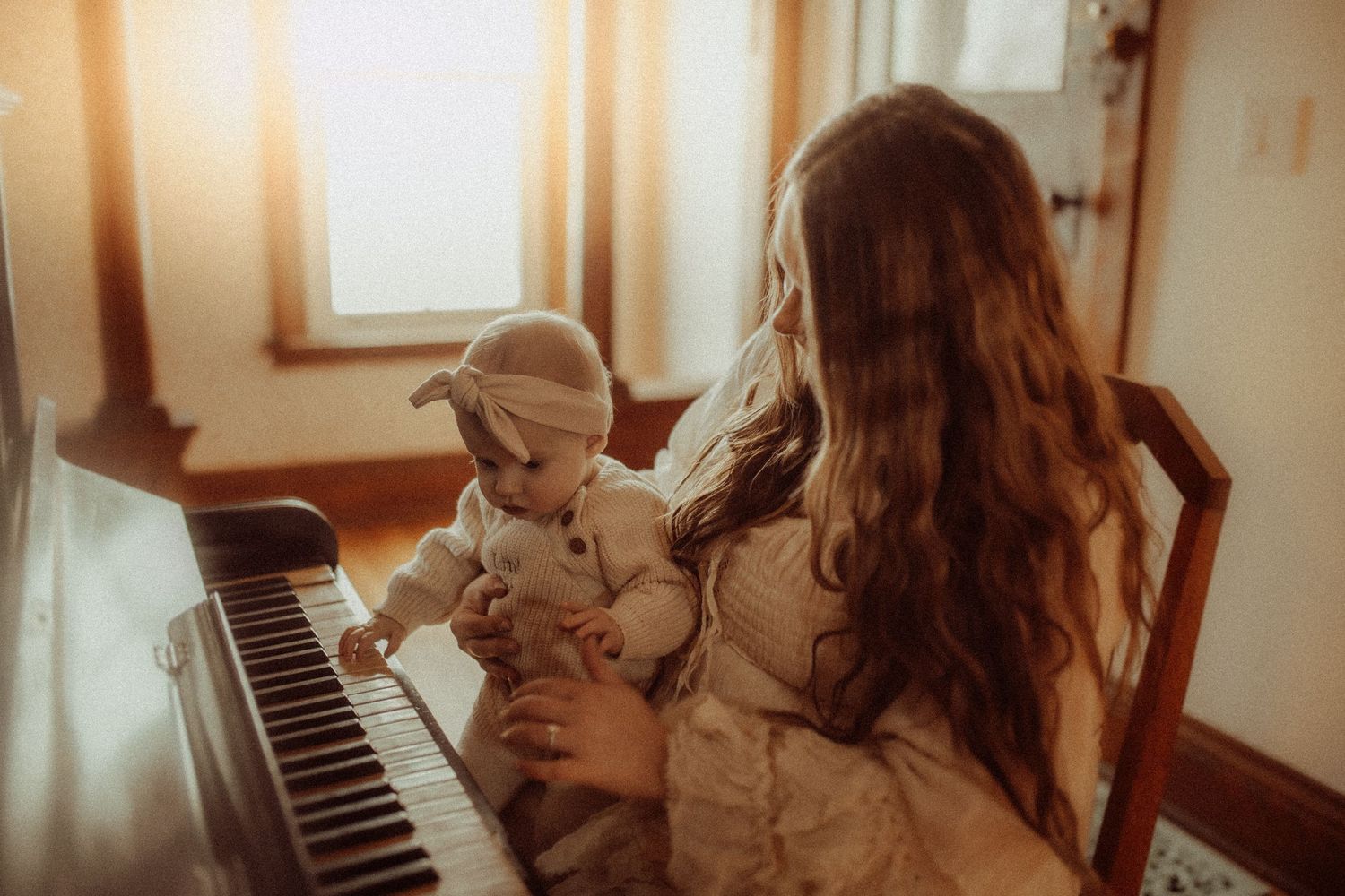 Orono, ON family photographer took a photo of a mama with her baby in golden light near a piano.  Tips for how to include moms in photos
