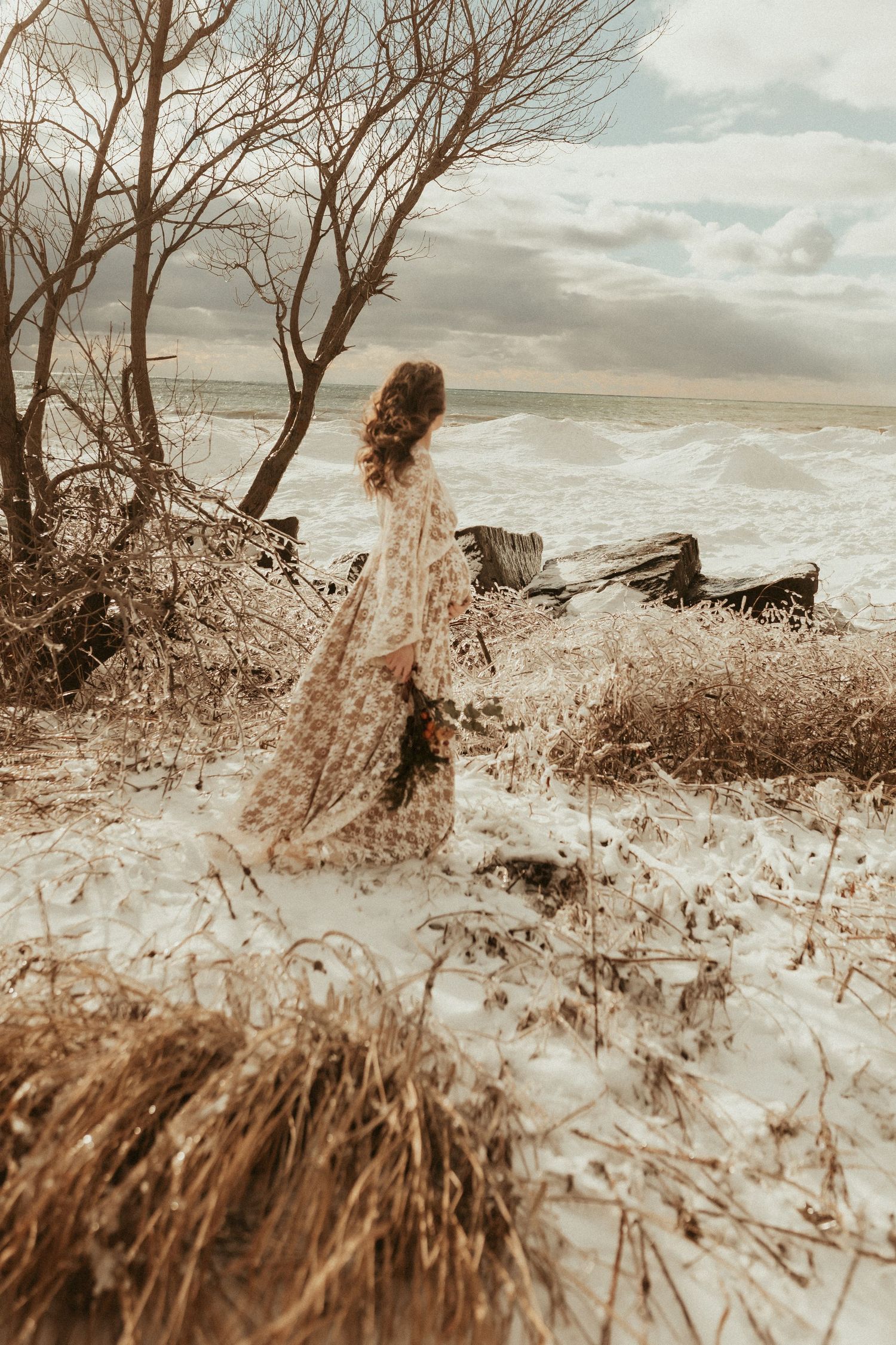 Winter  maternity session in Cobourg with expecting mom on an icy beach in a gorgeous lace maternity gown.