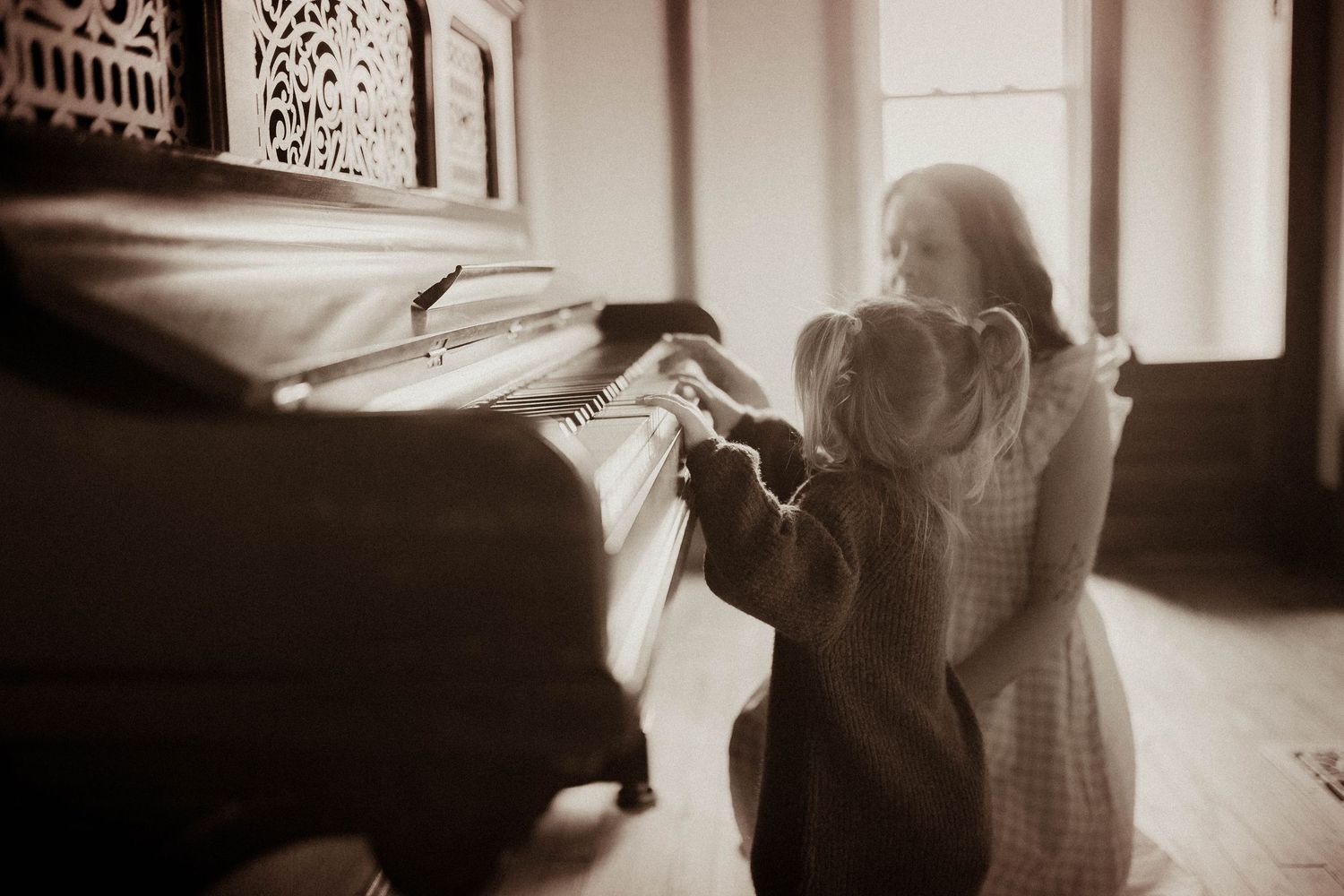 Mother and daughter playing piano together during an authentic motherhood photography session in Durham Region, Ontario