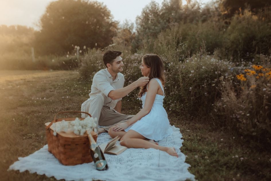 Romantic picnic with a couple at sunset surrounded by wildflowers and ethereal light.
