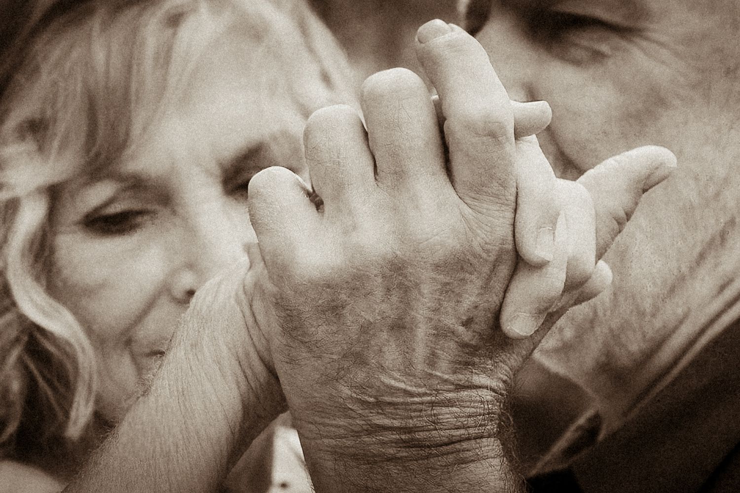 Intimate black and white photo of two people holding hands in a tender embrace taken by a Bowmanville, ON family photographer