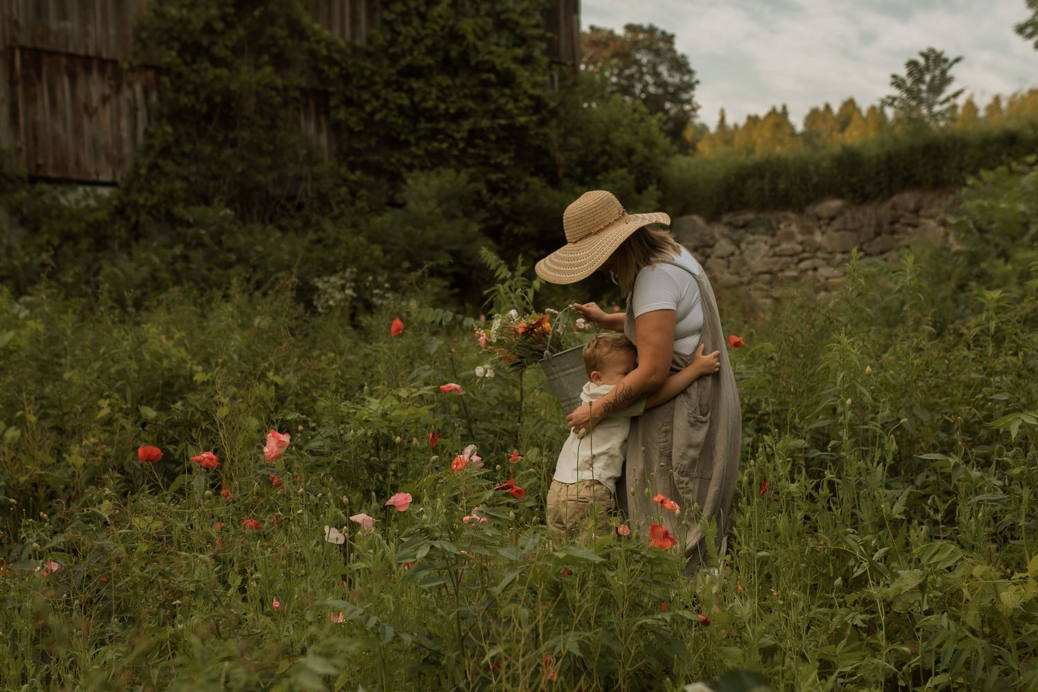 Mother embracing her young son in a wildflower field during a family photography session in Bowmanville, Ontario
