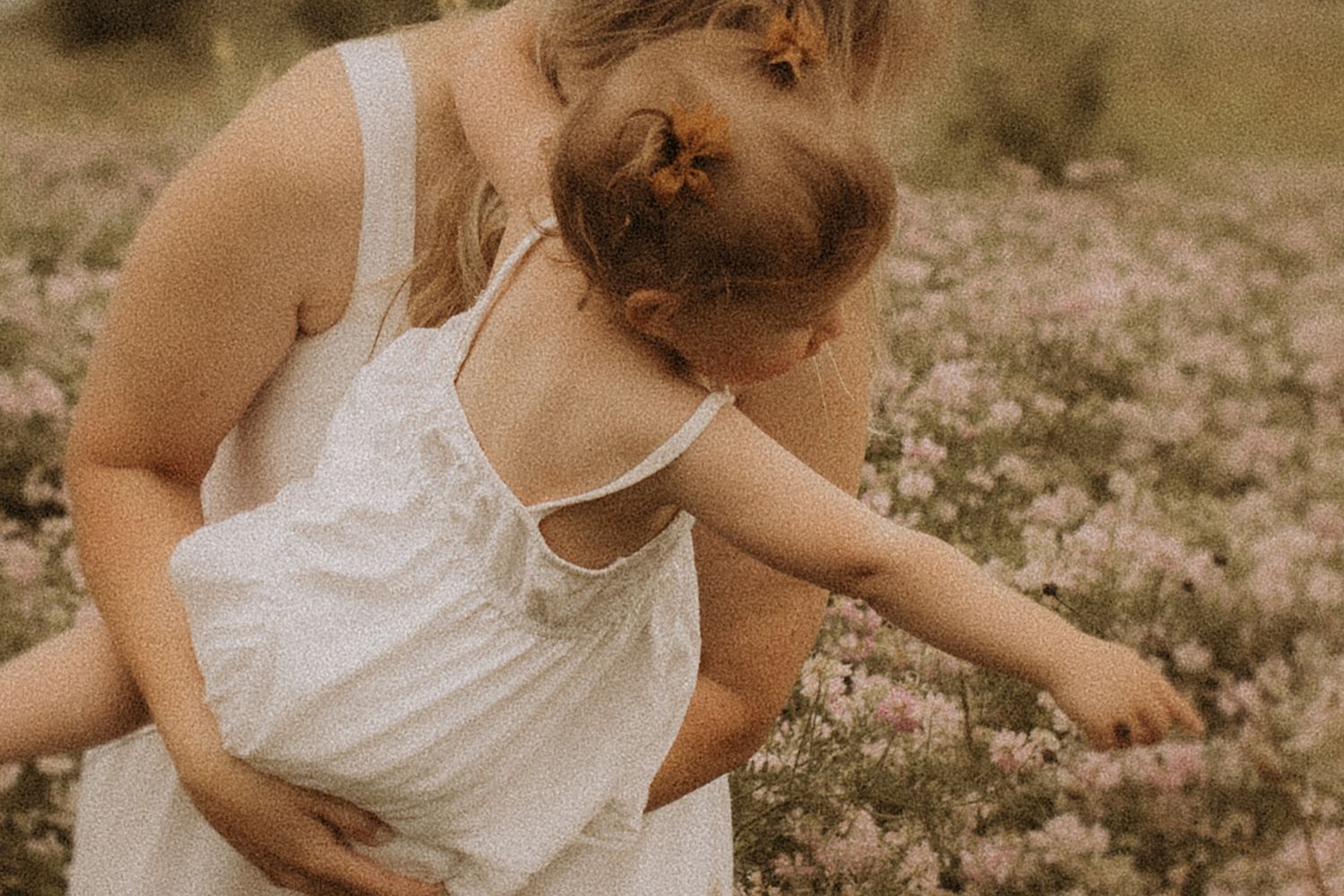 close-up of mom and daughter admiring the wildflowers near the beach by Cobourg family photographer