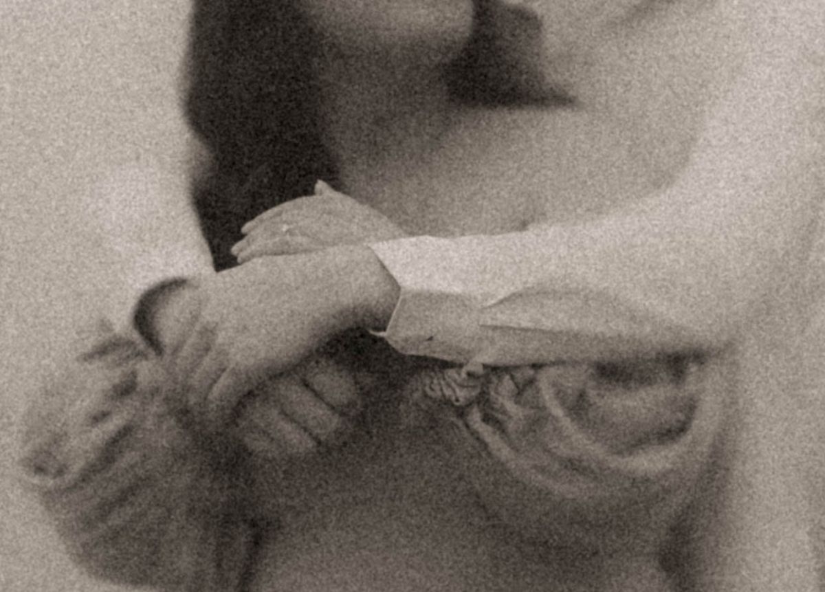 Grainy black and white close-up of a couple wrapped in a tender embrace, by artistic family photographer Bowmanville, ON.