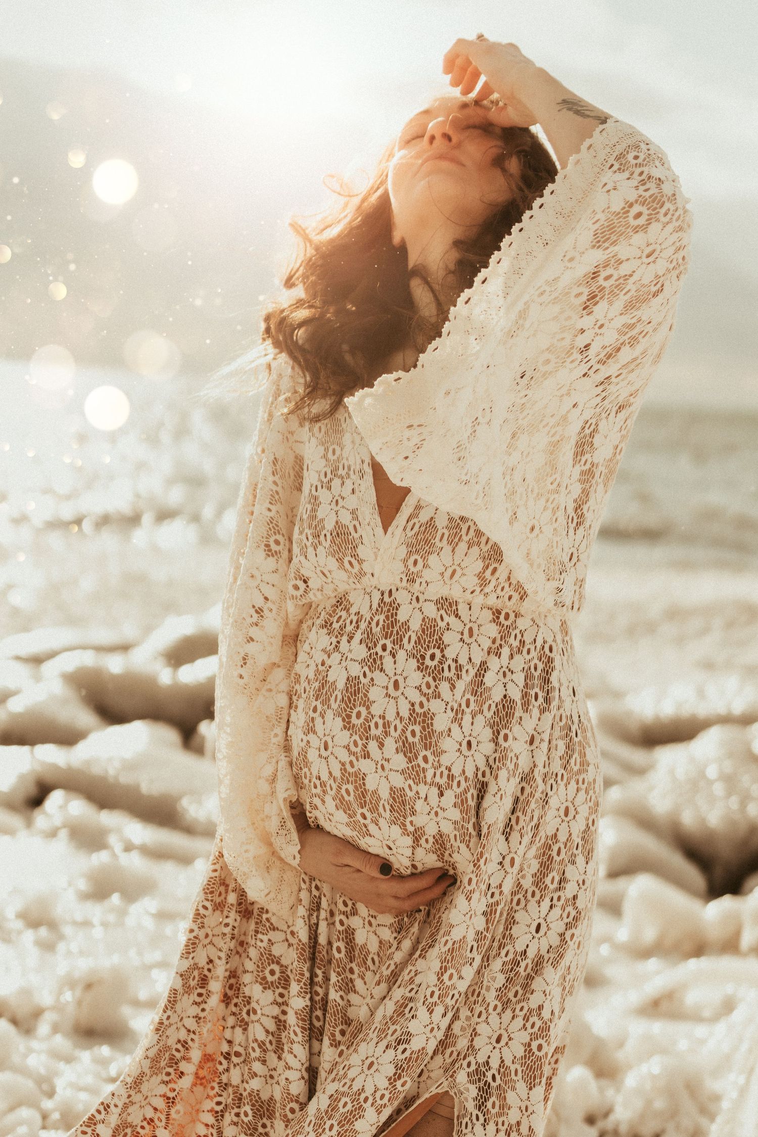 Bowmanville family photographer captures a maternity session on a winter beach of a pregnant mom in lace dress