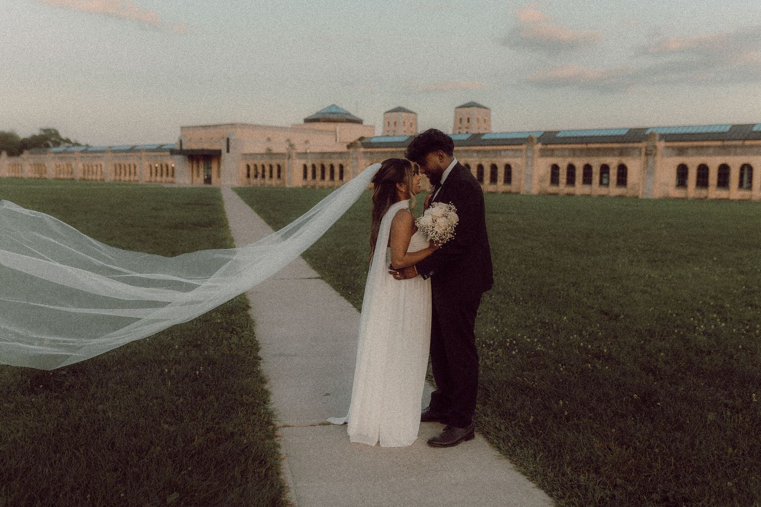 Couple kissing in front of R.H. Harris building in Toronto by candid wedding photographer Durham Region