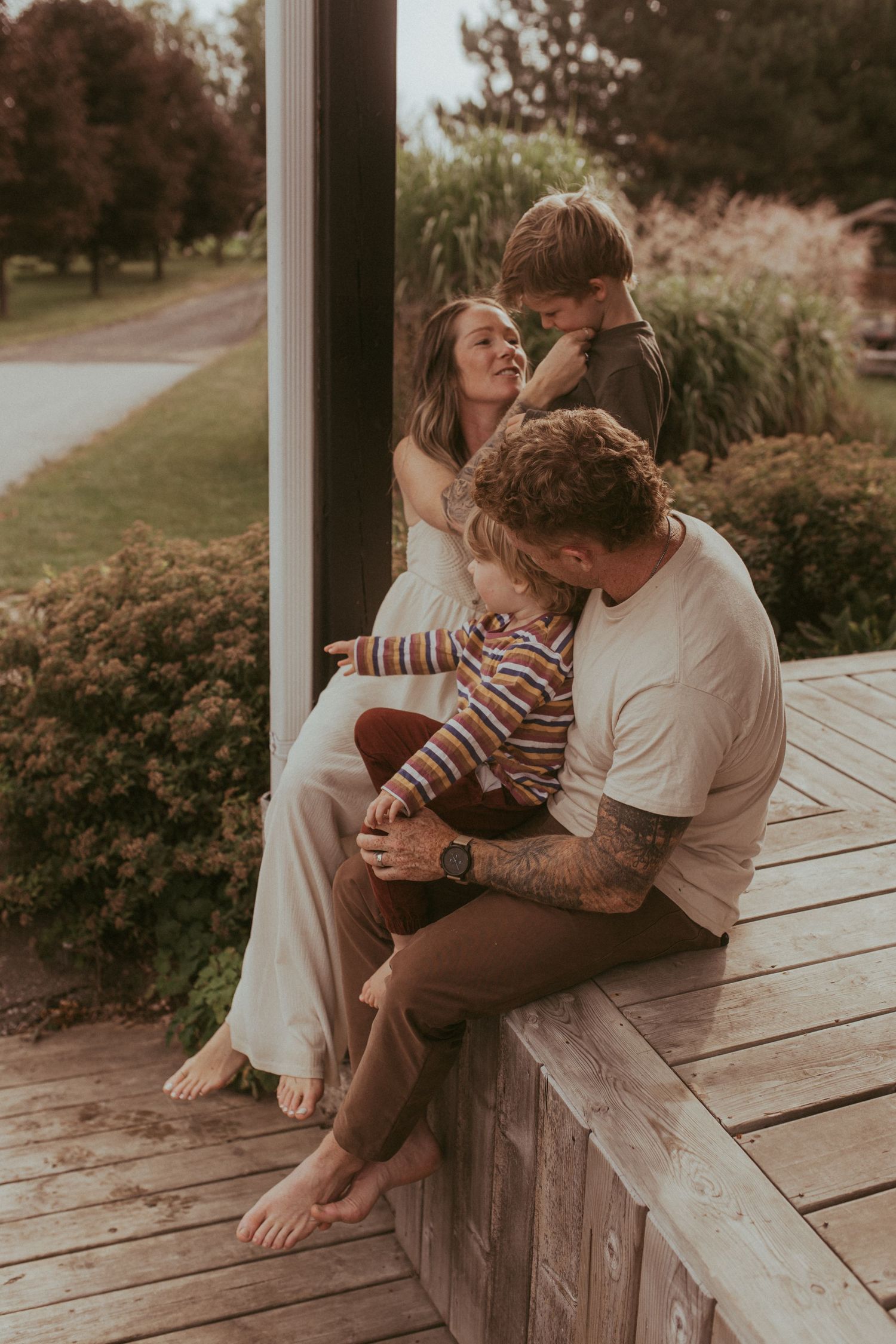 Family interacting together on a front porch by Bowmanville maternity photographer
