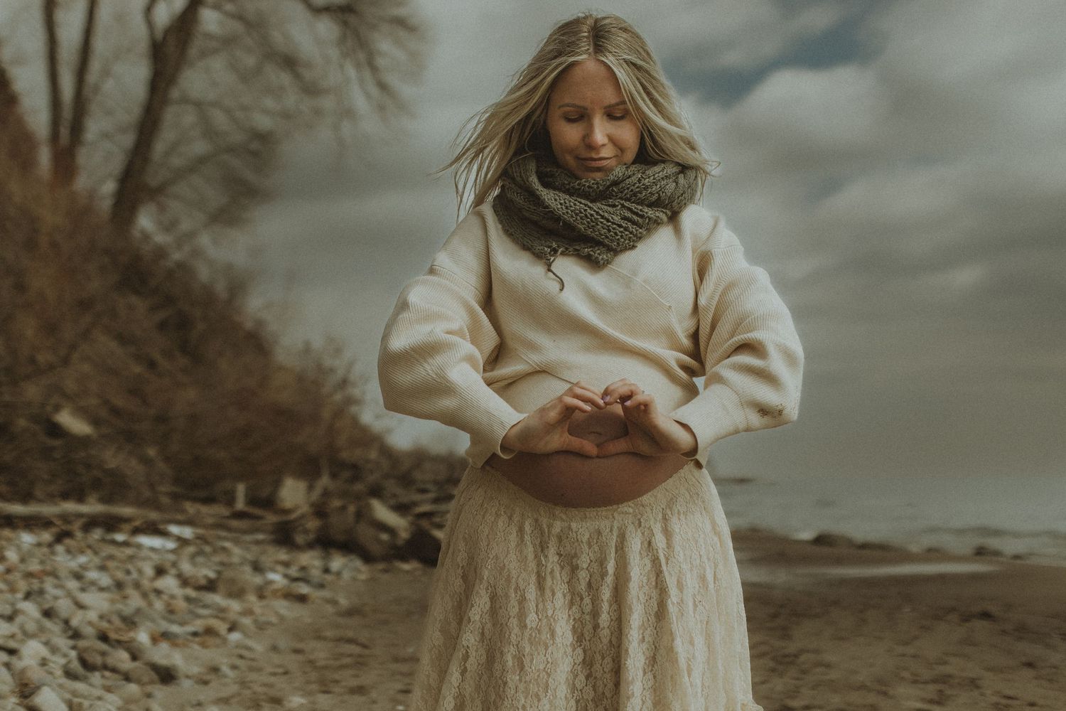 Expecting mom making a heart on her bump with her hands taken by Bowmanville, ON family photographer