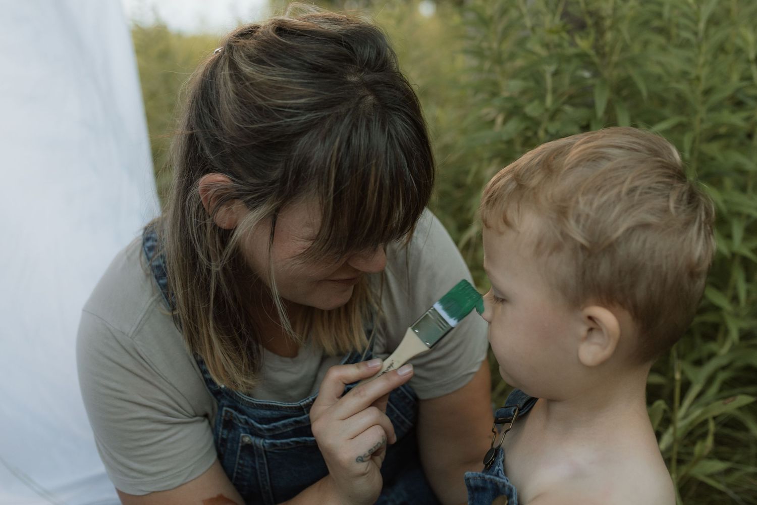 A mom playfully painting her son's nose during a painting session by Courtice family photographer