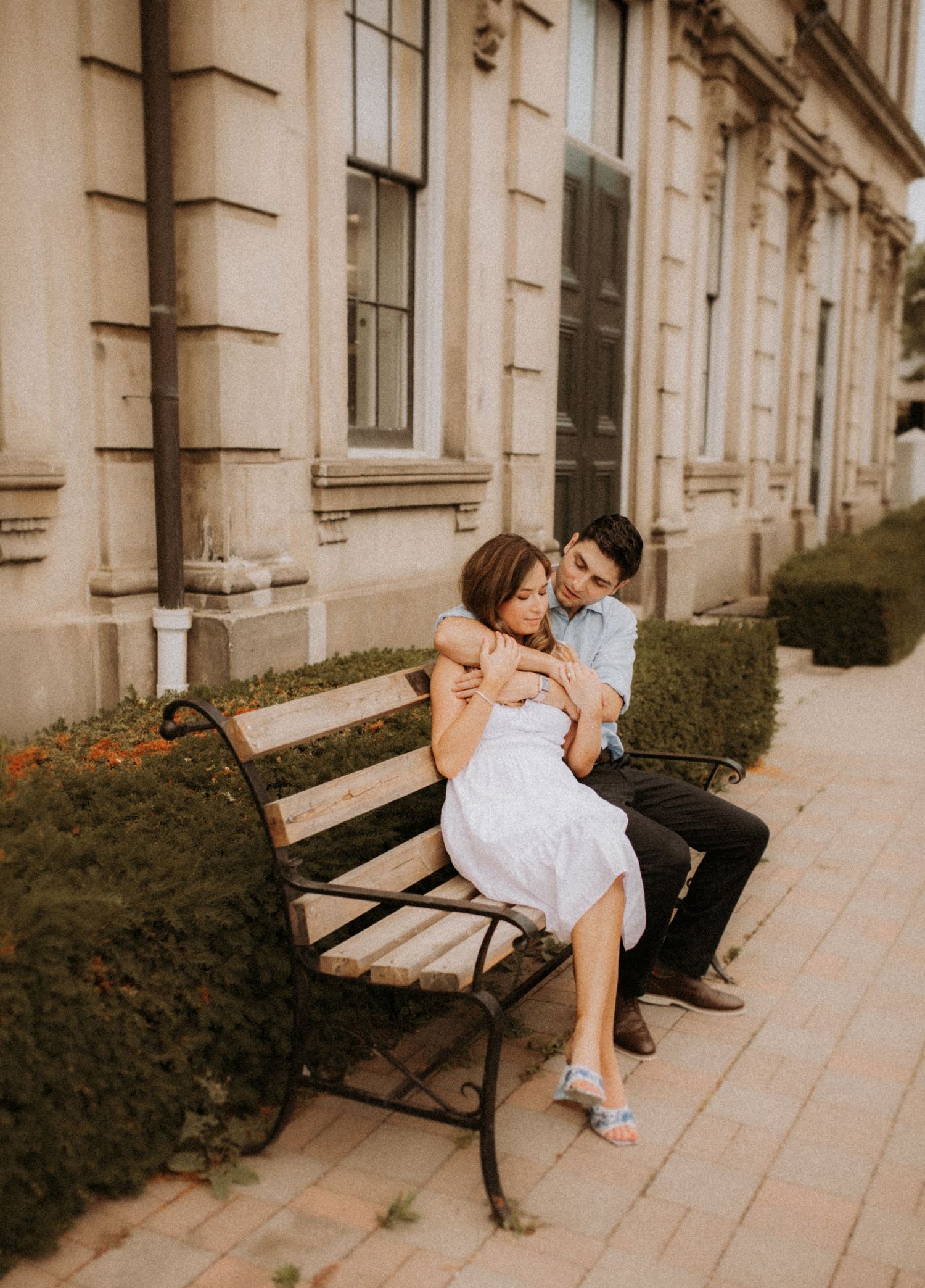 A newly married couple sit on a bench outside Victoria Hall after they eloped by Cobourg Elopement Photographer