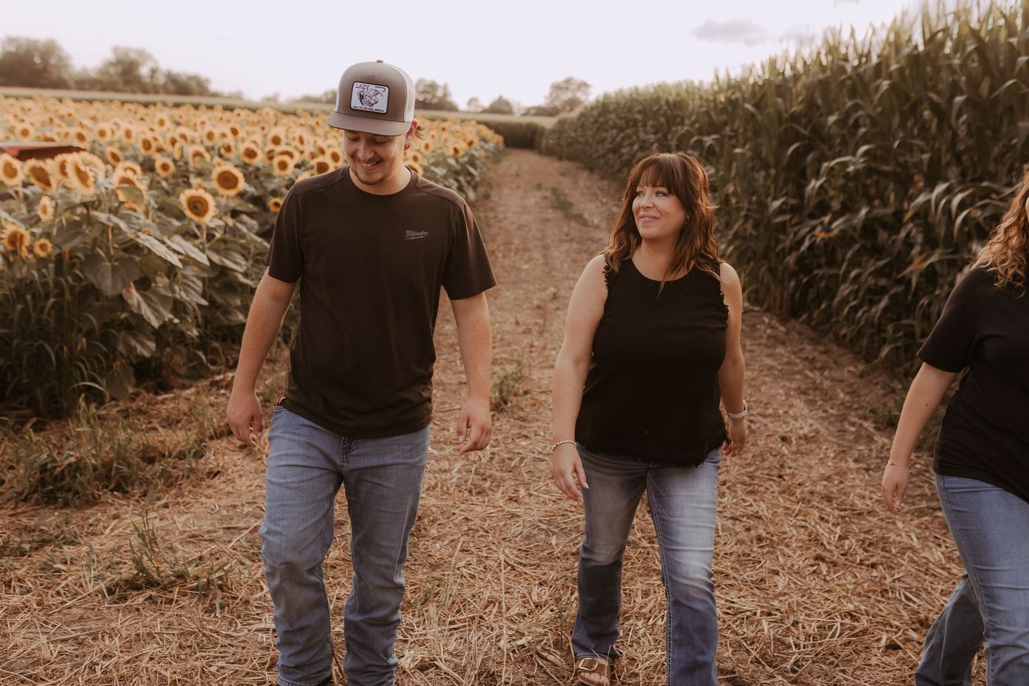 Mom talking and laughing with her teenage son in a sunflower field by Durham Region maternity photographer