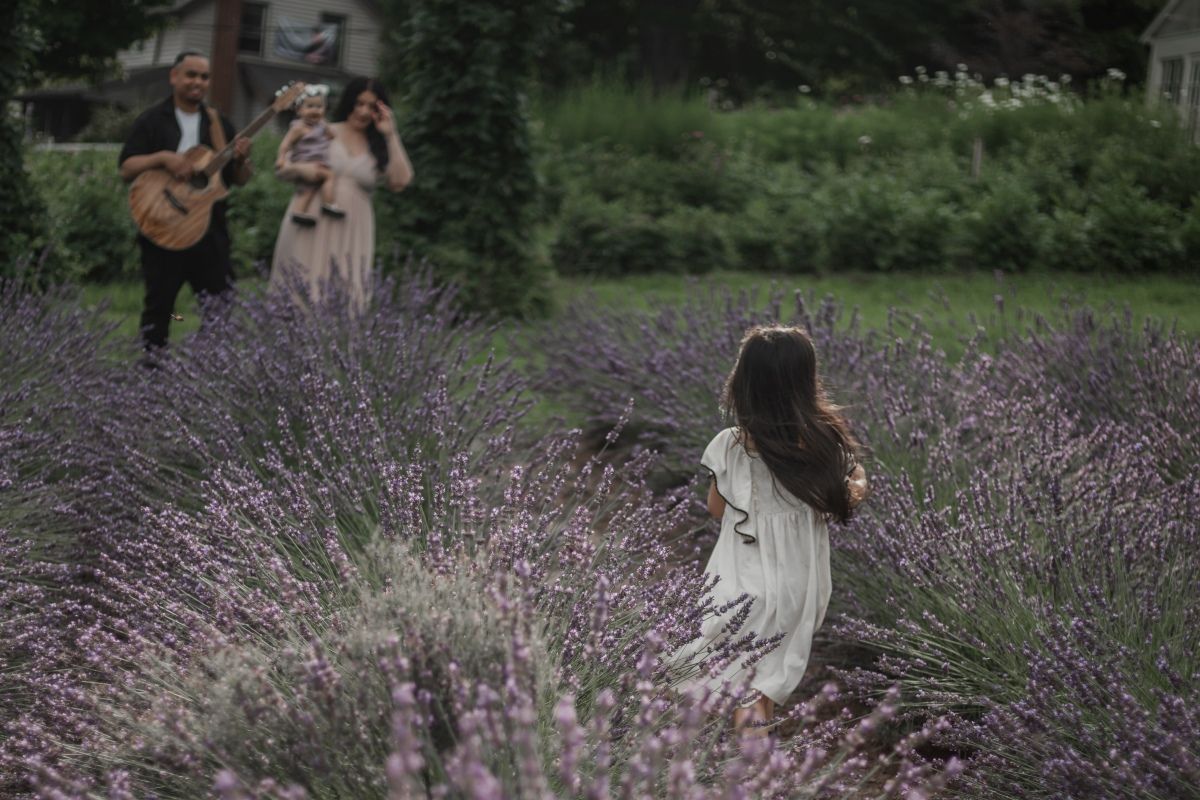 Candid family session in a blooming lavender field, surrounded by purple flowers by artistic family photographer Bowmanville, ON.