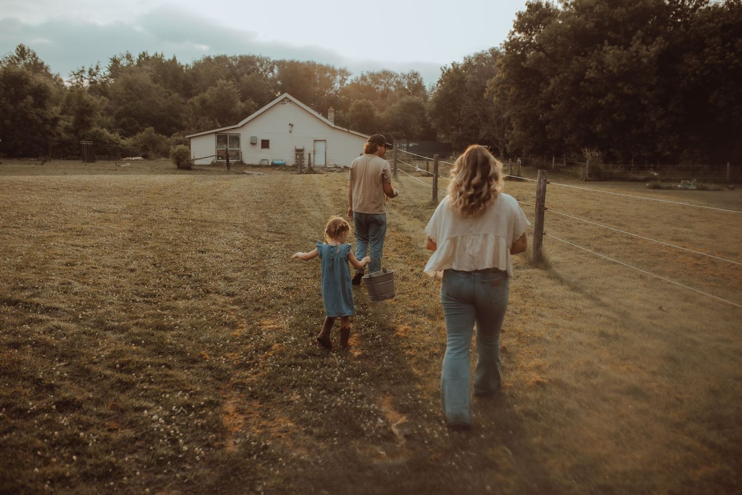 A family walking to the barn to feed the chickens in the early morning light by Bowmanville, ON family photographer.