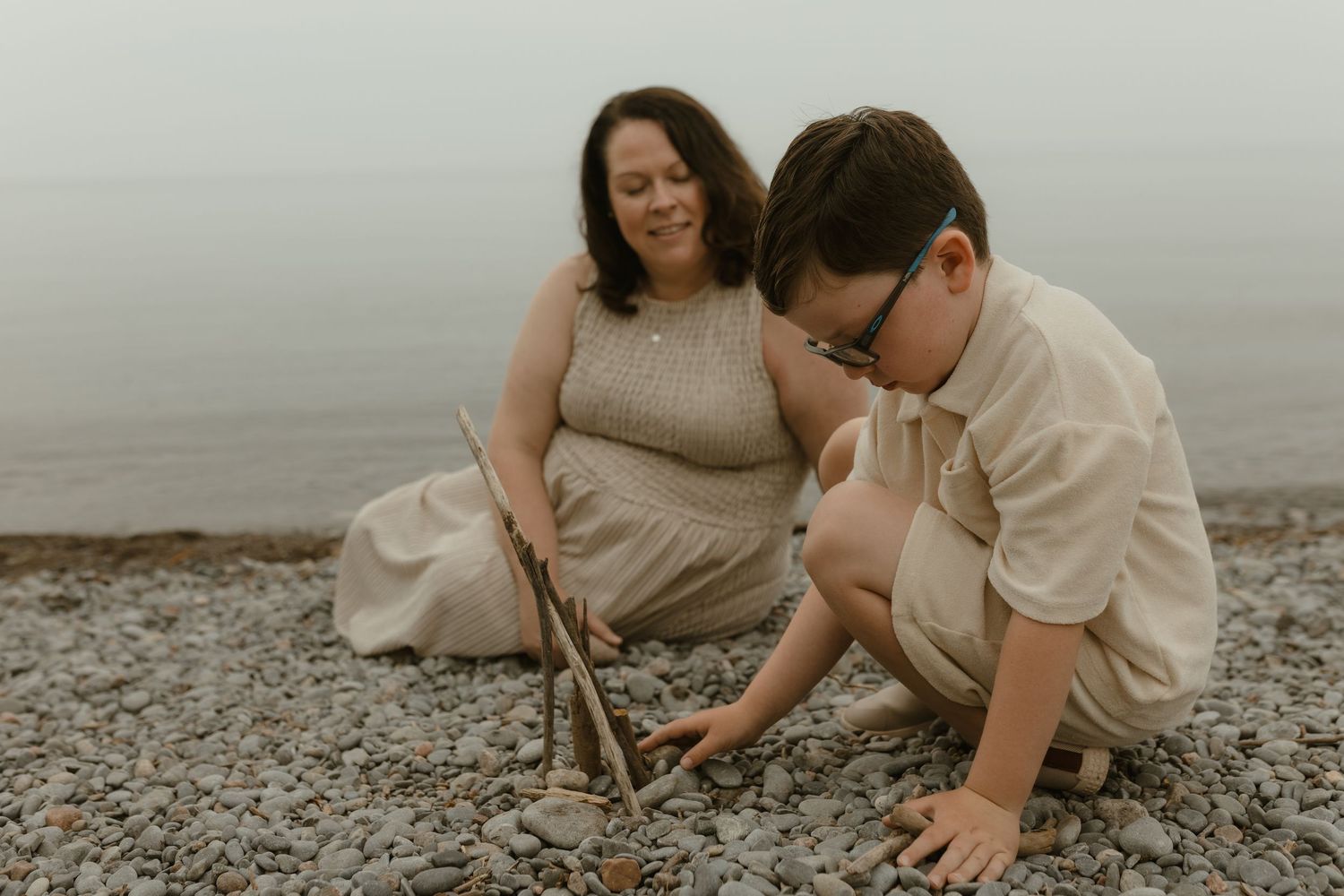 A mother and son sharing a quiet moment on moody beach by Durham Region motherhood photographer