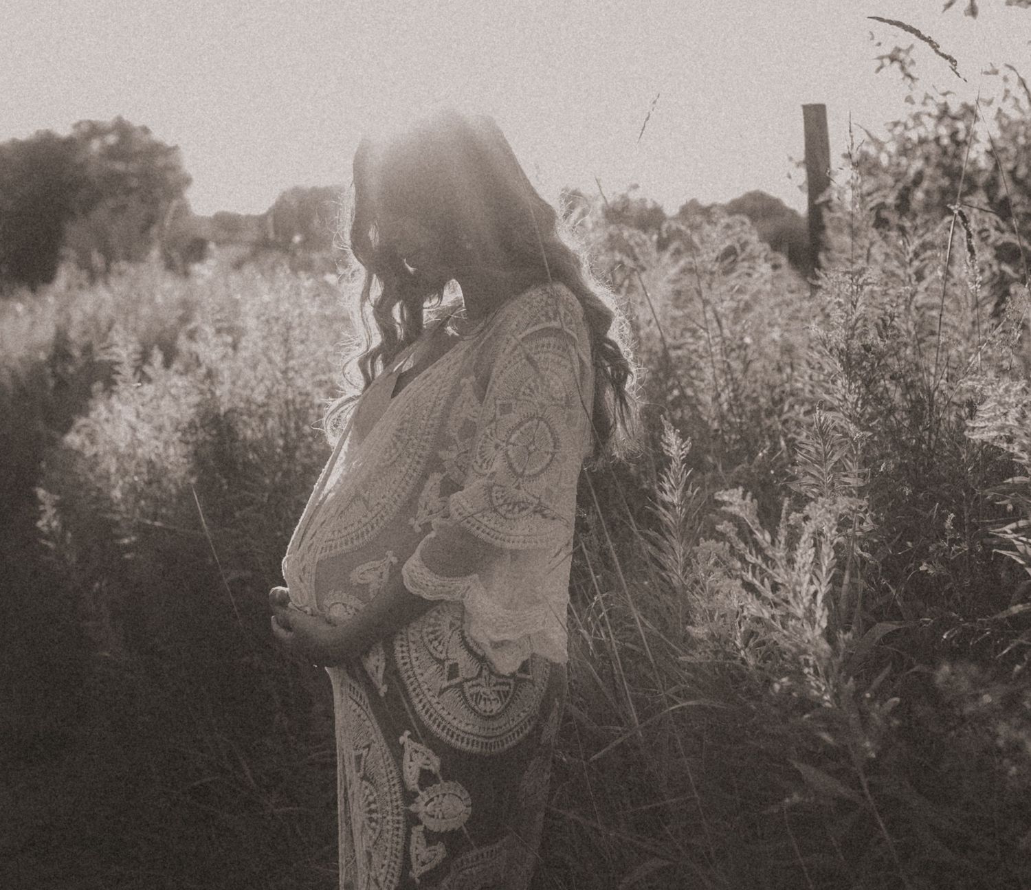 An expectant mother bathed in sunset light, symbolizing peace, hope, and new beginnings.