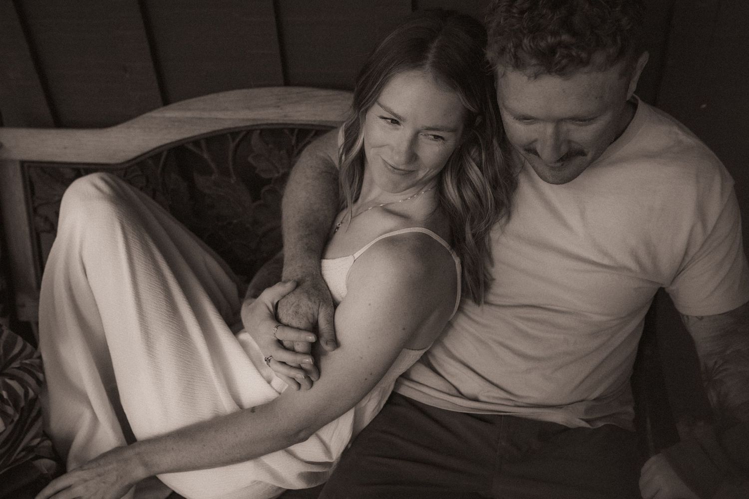 A couple cuddle together on a chair during a Durham Region family lifestyle photography session