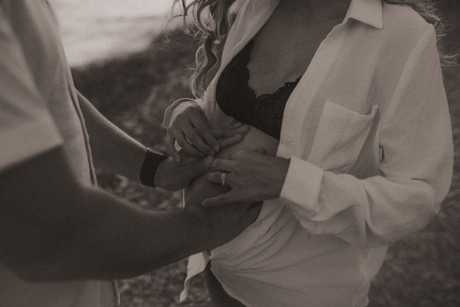 Beach maternity session with a close-up shot of a couple holding her belly bump taken by a Bowmanville, ON family photographer.