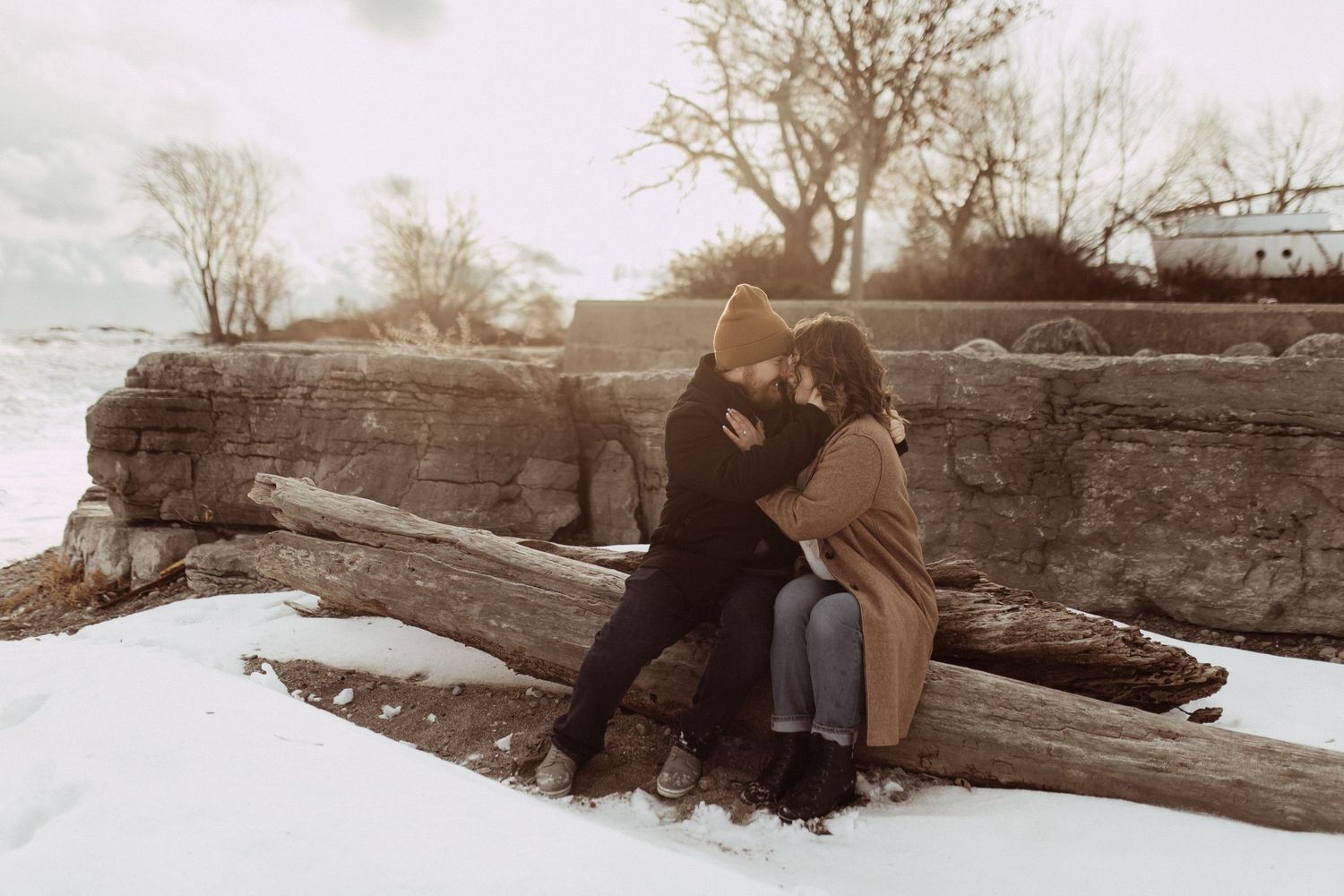 Romantic engagement photo shoot of a couple sharing an intimate moment on a beach by artistic family photographer Bowmanville, ON.