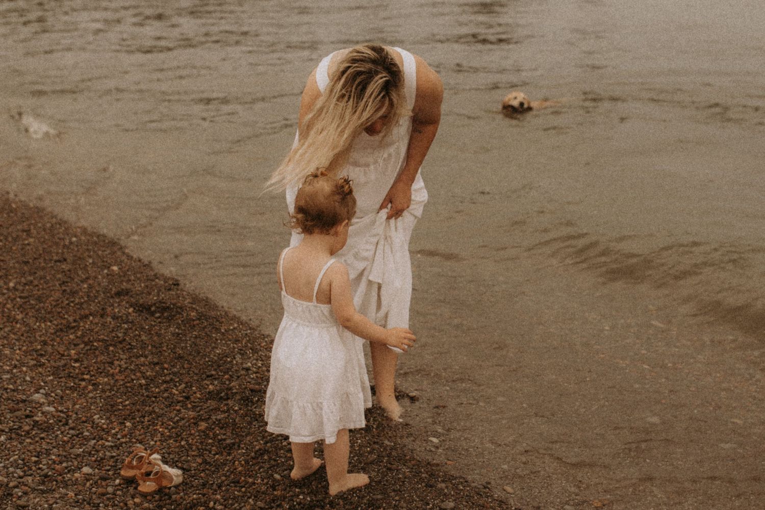 A mom and daughter on the shore sharing a private moment by Cobourg family photographer