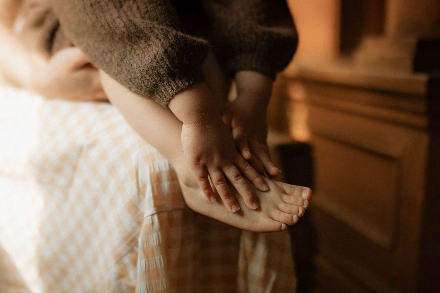 Close-up of tiny hands and feet during an in-home family session by Oshawa Family Photographer.