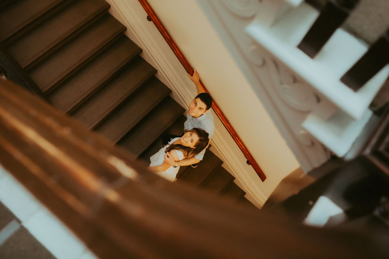Artsy shot of an eloping couple climbing the sweeping staircase at Victoria Hall by Cobourg Wedding and Elopement Photographer