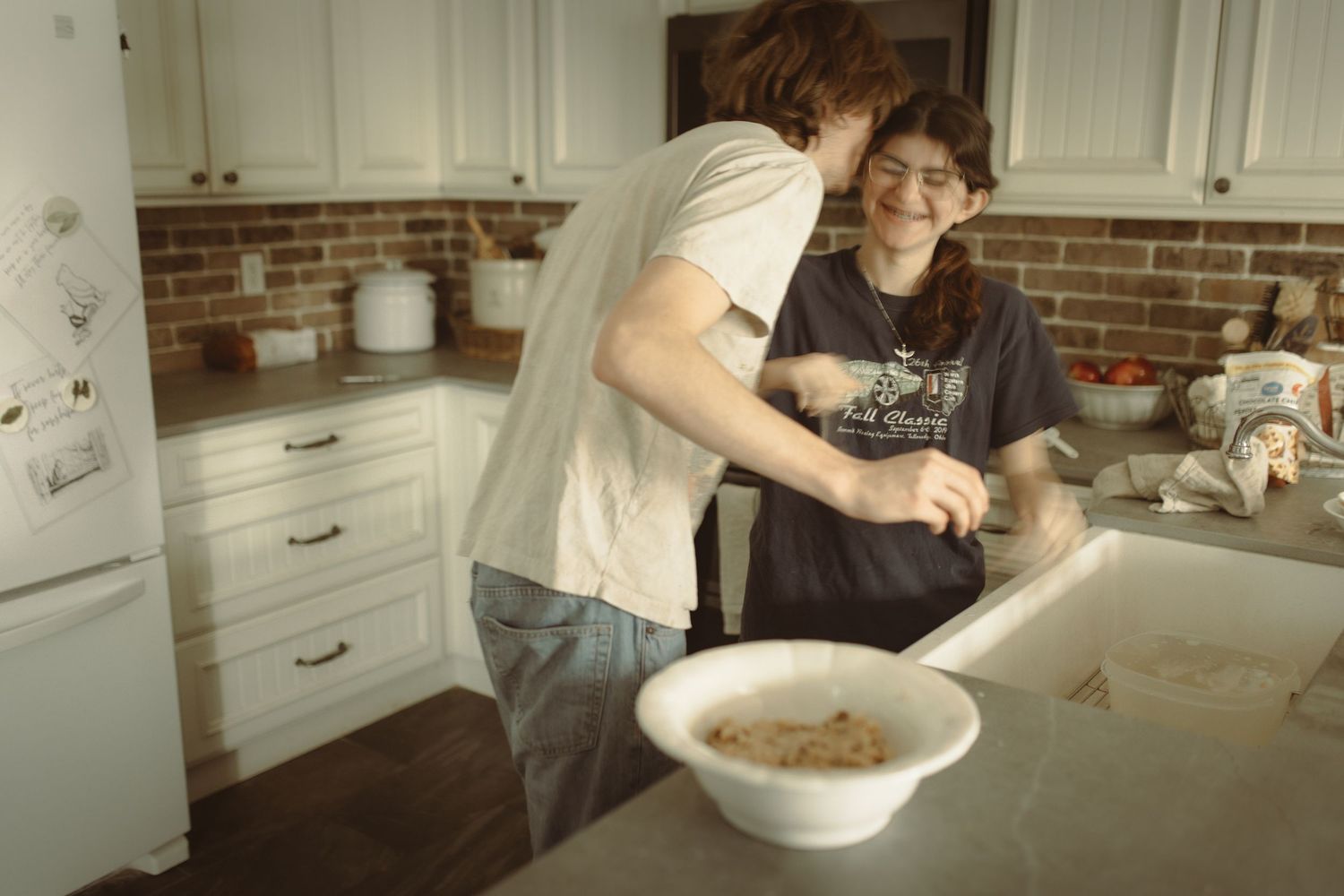 Two teenagers baking together in the kitchen - real connection and moments documented by your Durham Region Family Photographer.