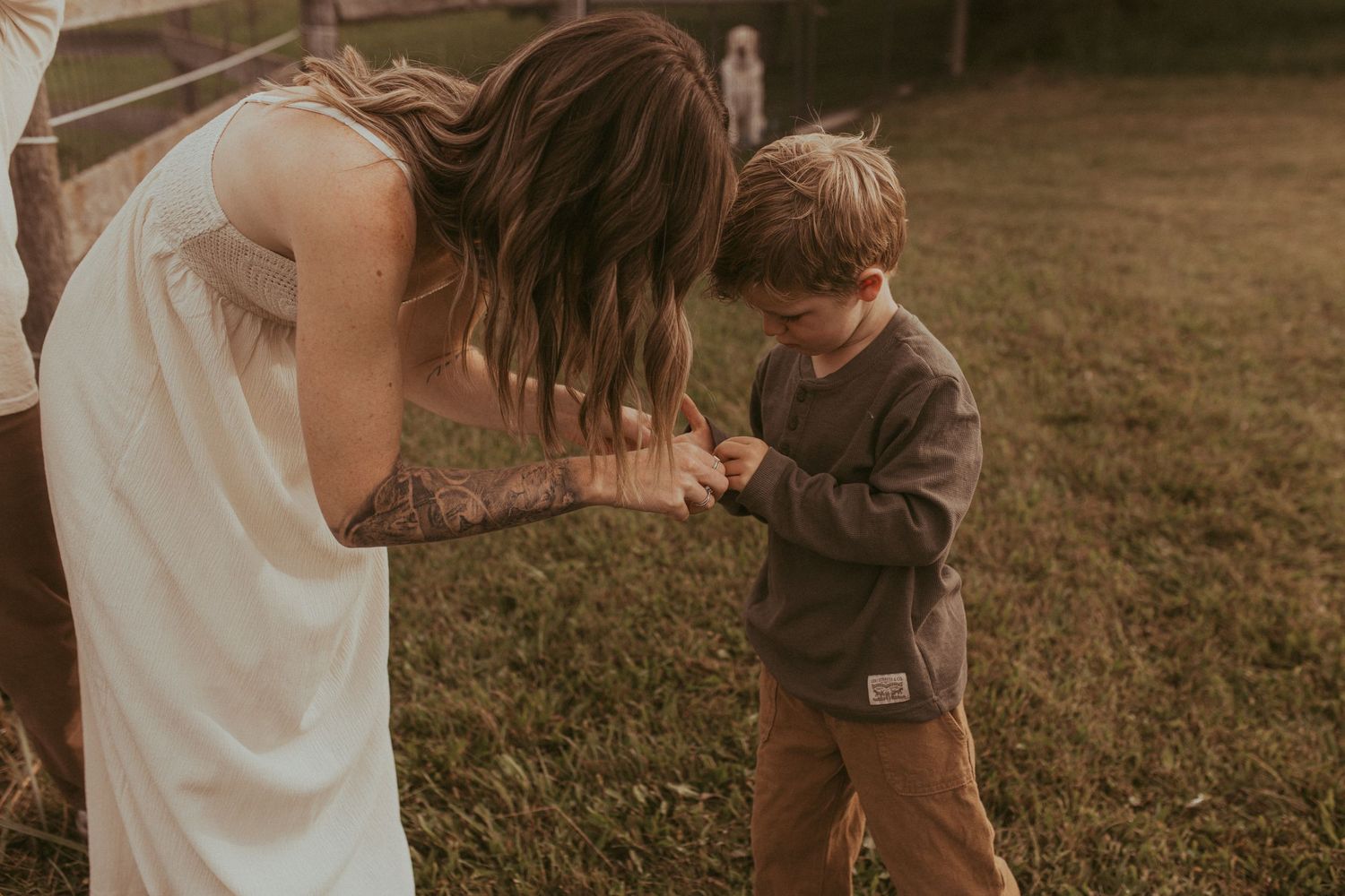 A mom examines her young son's hand to look for a boo-boo during a Durham Region family lifestyle photography shoot.