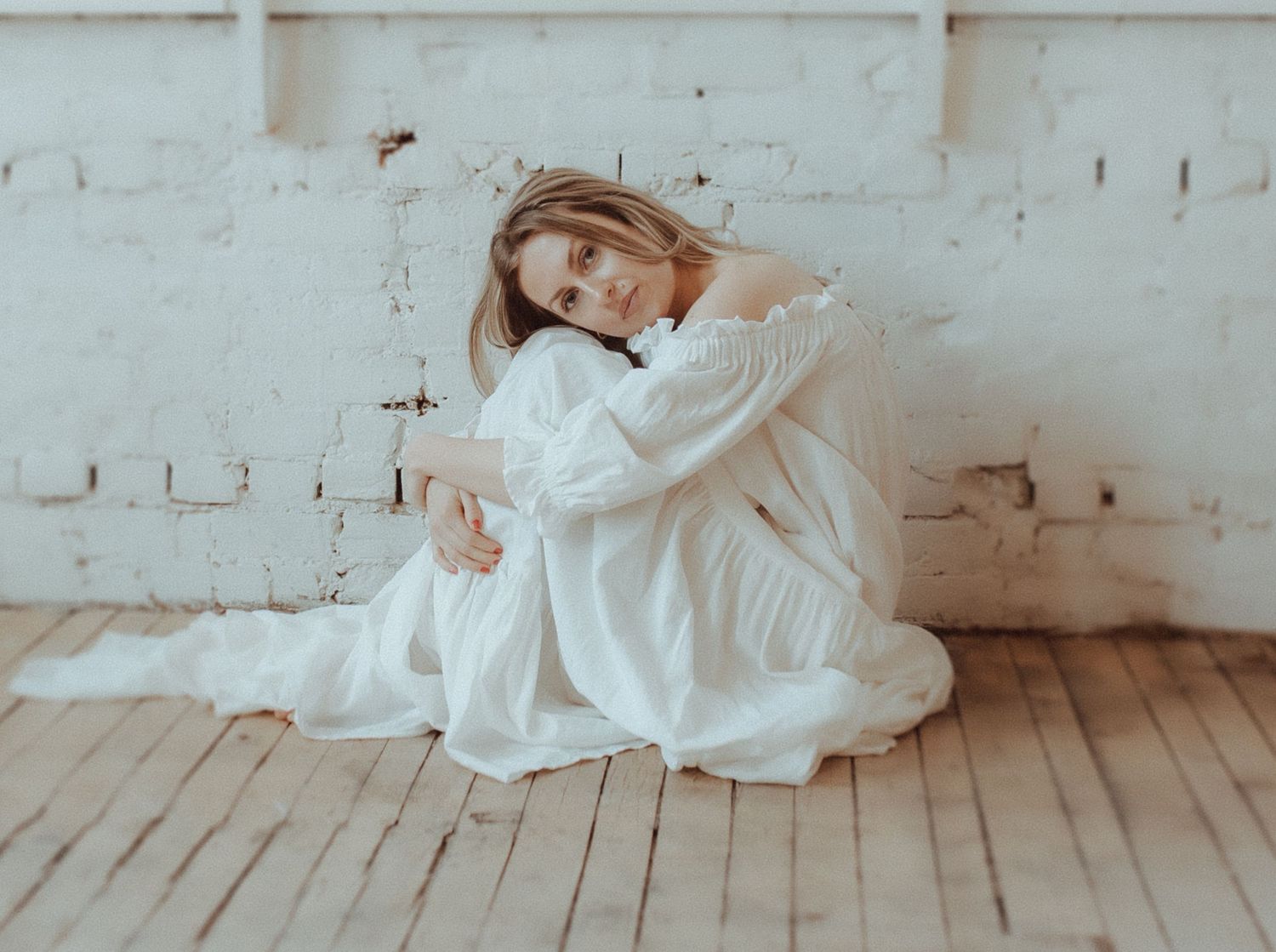 Series of elegant poses in white dress shown against minimalist studio backdrop.
