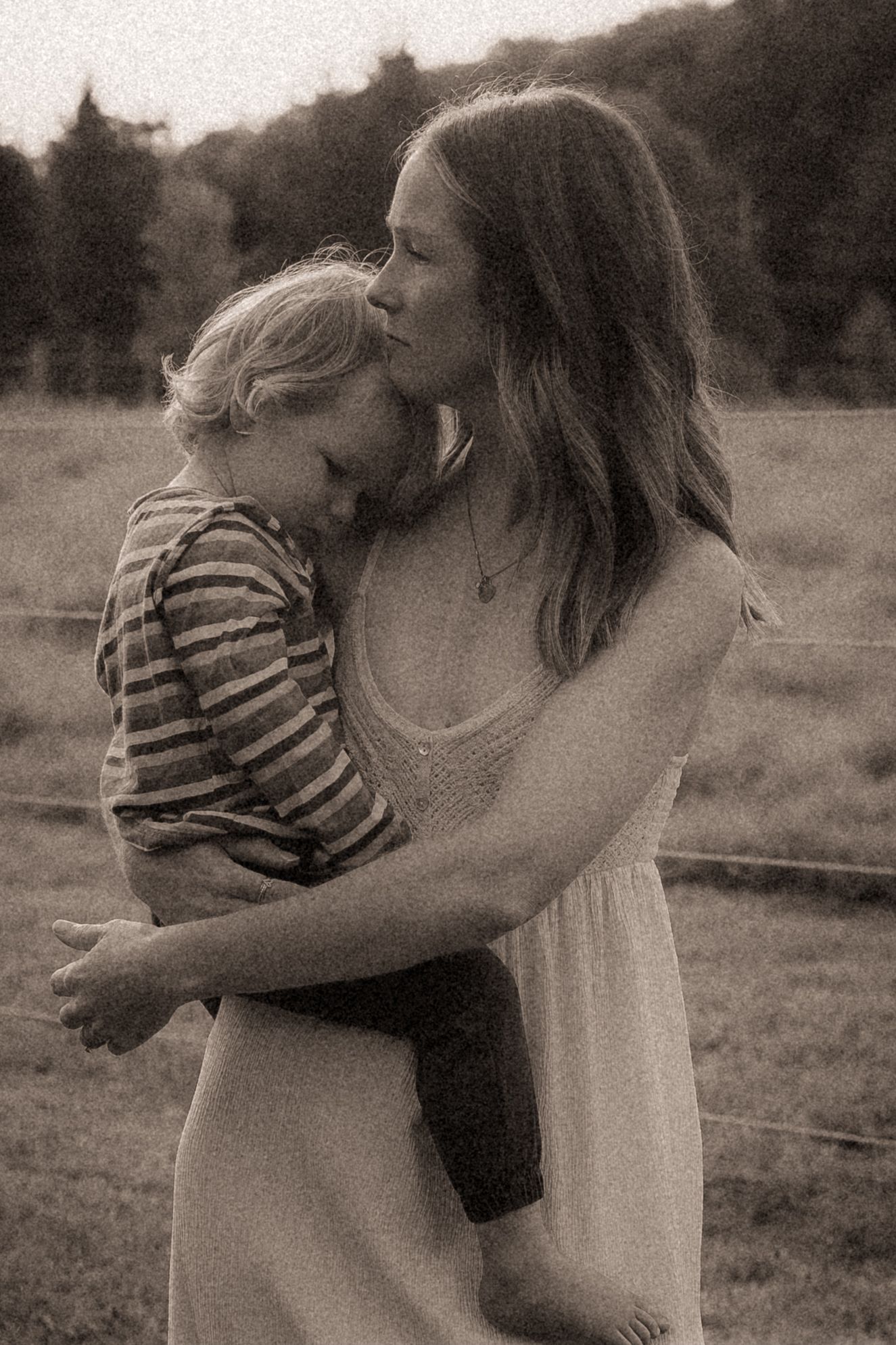 Close-up image of a mom cradling her son in her arms with a serious expression by Durham Region maternity photographer
