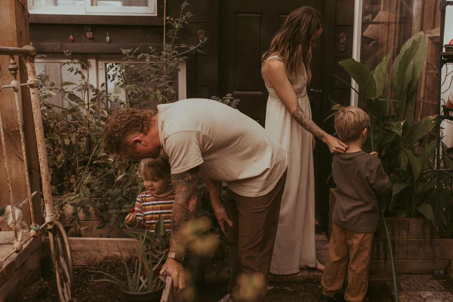 Young family in a greenhouse working together during a family lifestyle session in Durham Region, Ontario