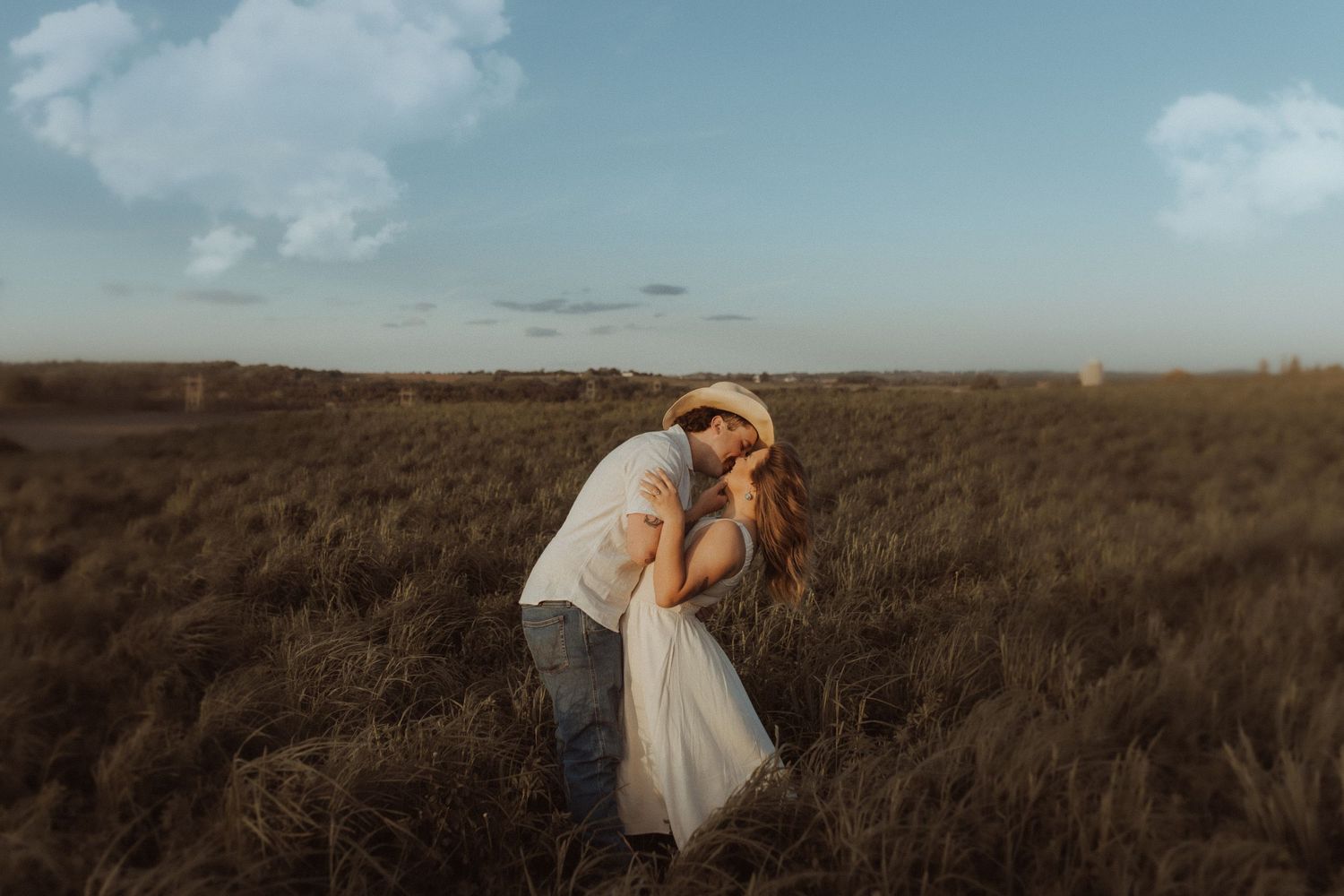 Lovely engagement session in a field at sunset.  He gently tips her back for a kiss by Bowmanville, ON family photographer.
