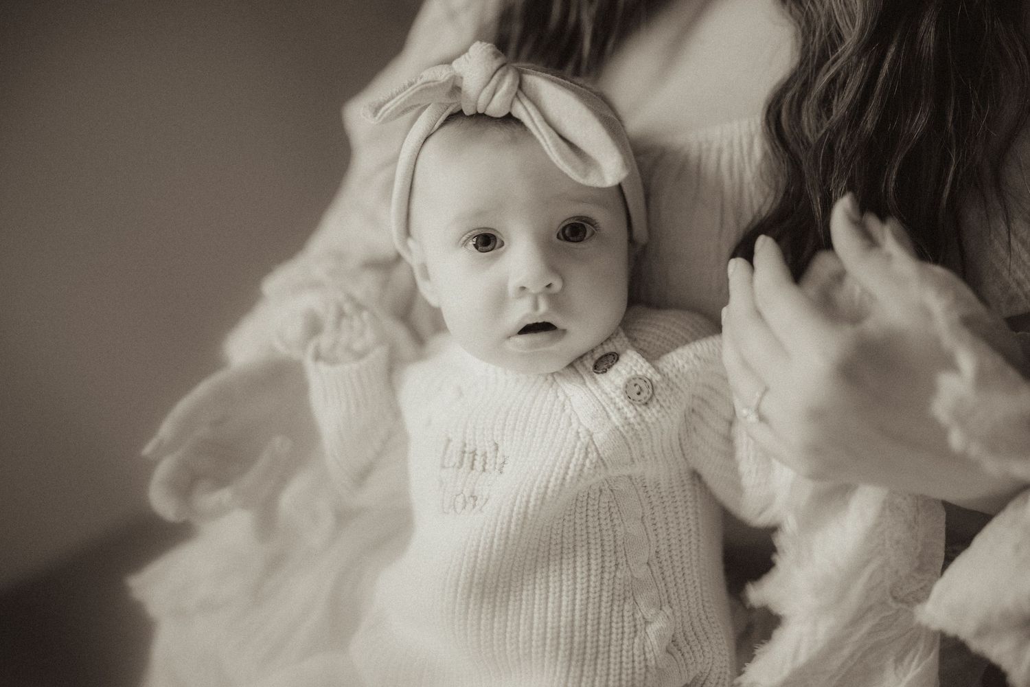 Close-up black and white image of a baby girl on her moms lap by Orono, ON family photographer.  Mom's need to be in the photos too.