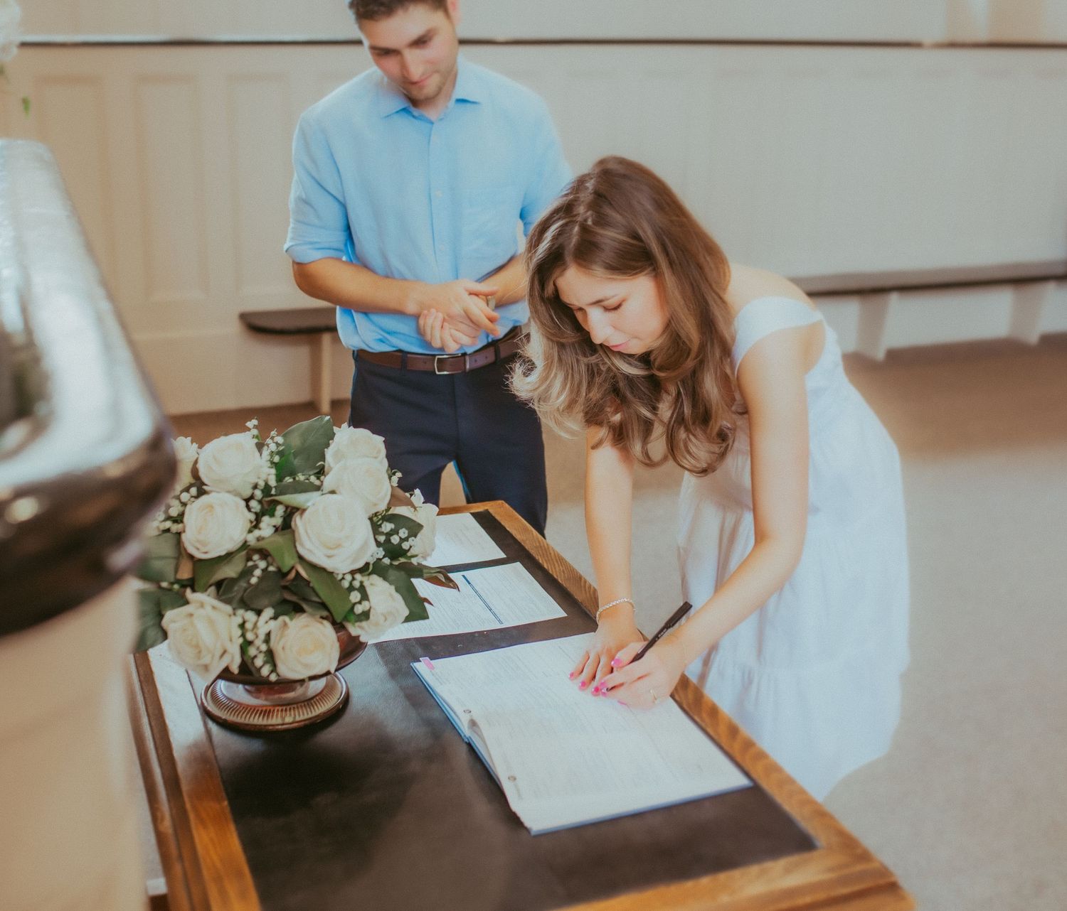 The happy couple sign the marriage certificate in the court house at Victoria Hall by Cobourg Elopement Photographer