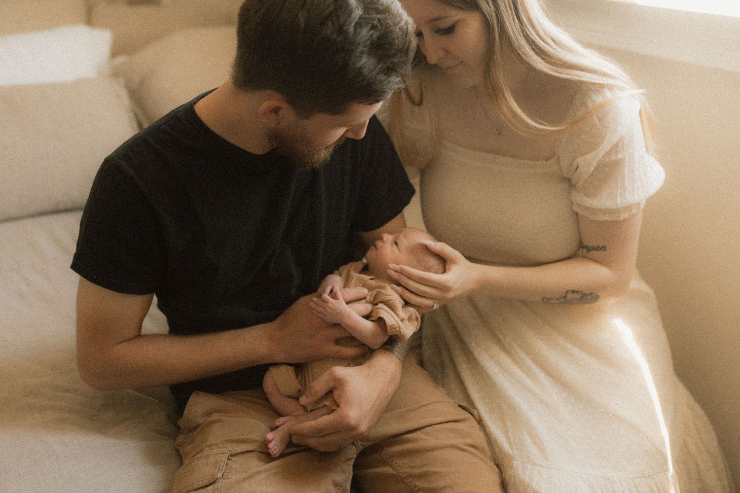 Close-up of young parents holding their newborn and gazing at him with love by newborn photographer in Bowmanville, ON
