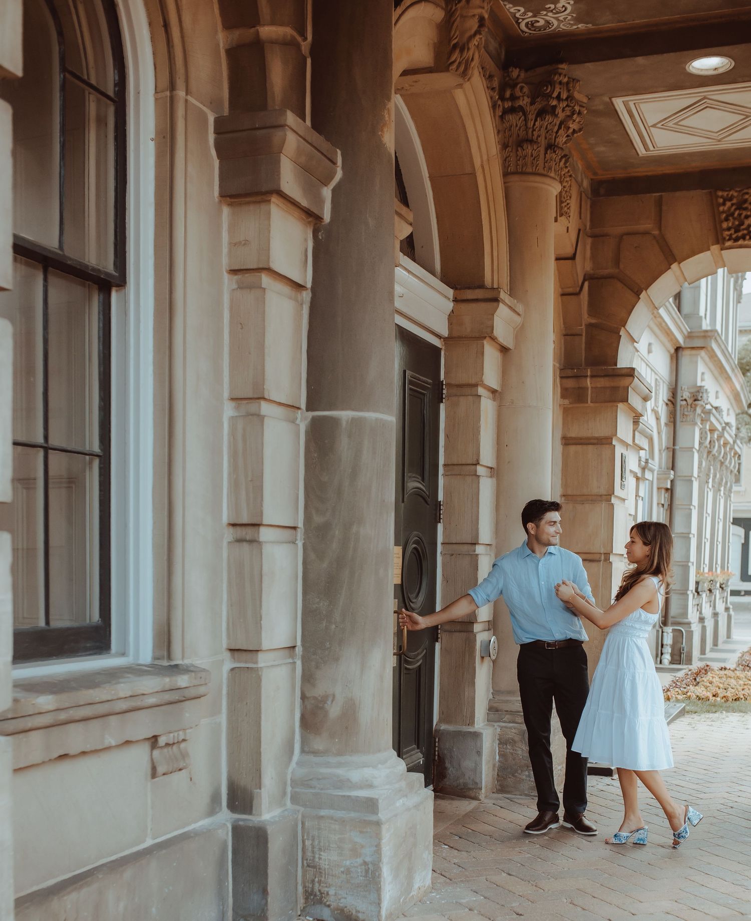 A happy couple are opening the door to Victoria Hall as they are about to begin the next chapter by Cobourg Elopement Photographer