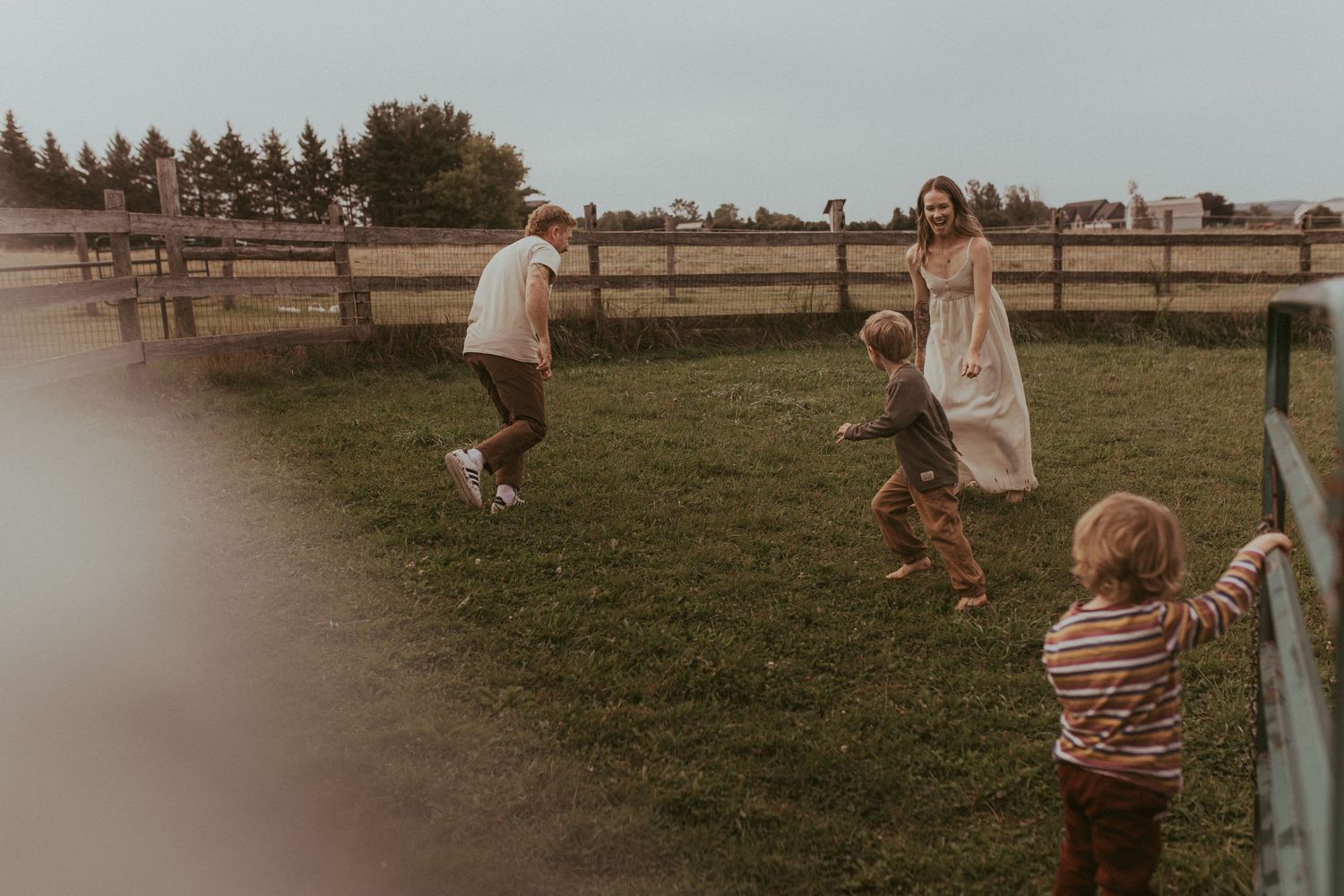 A family plays tag together outside by Durham Region family lifestyle photographer.