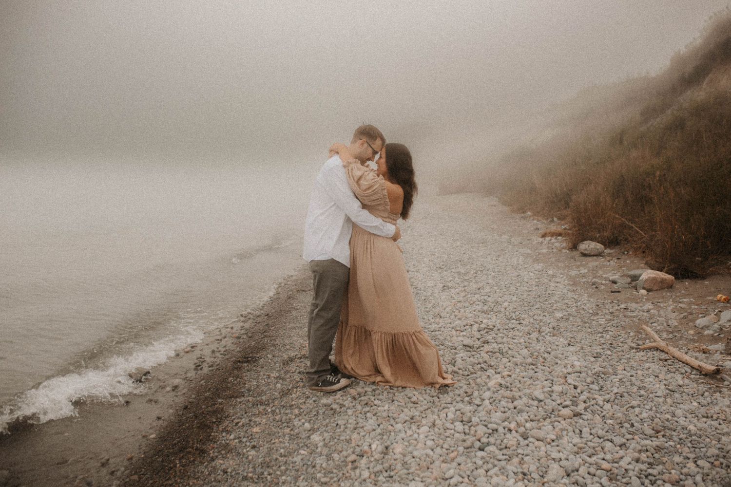 Engagement session on a foggy beach lost in a private moment by family photographer Bowmanville, ON
