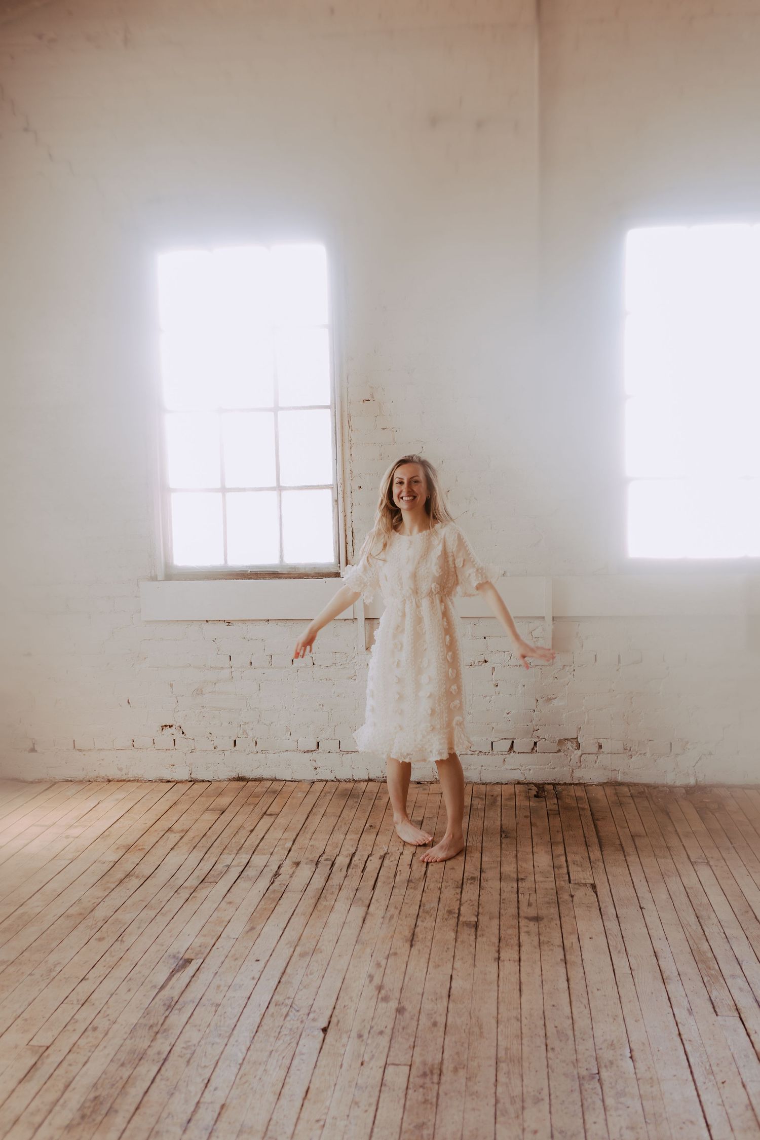 Flowing white dress creates ethereal movement sequence in bright studio setting.