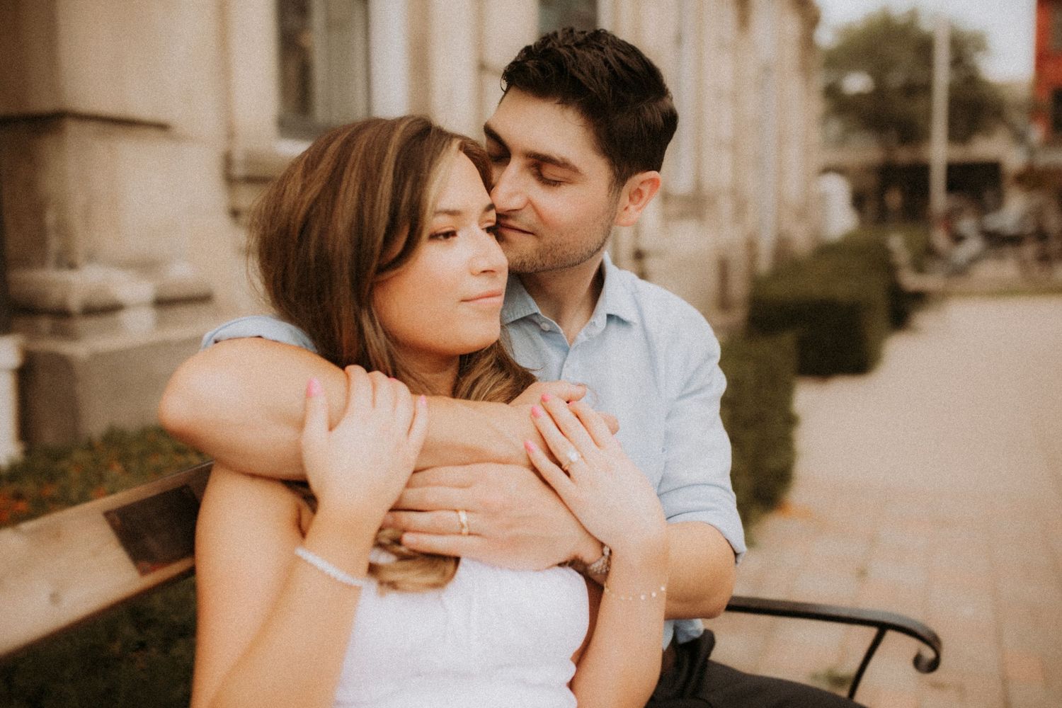 A close-up image of a couple on a bench outside of city hall after eloping by Cobourg Elopement Photographer