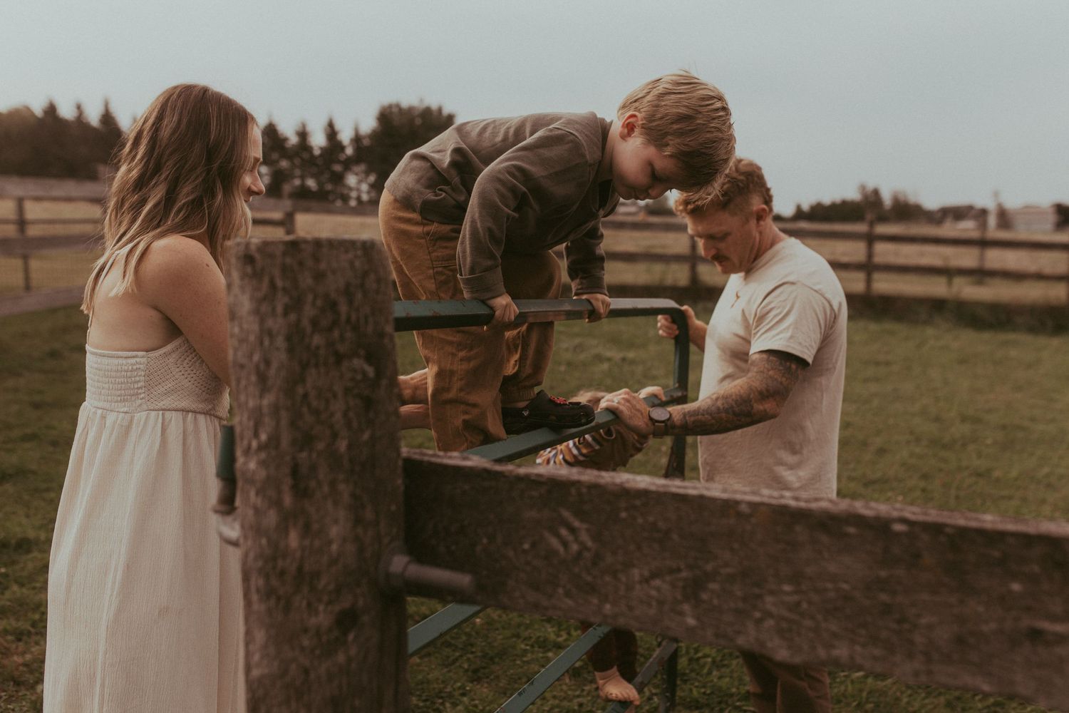 Children climbing a fence during an outdoor family session by Bowmanville family photographer