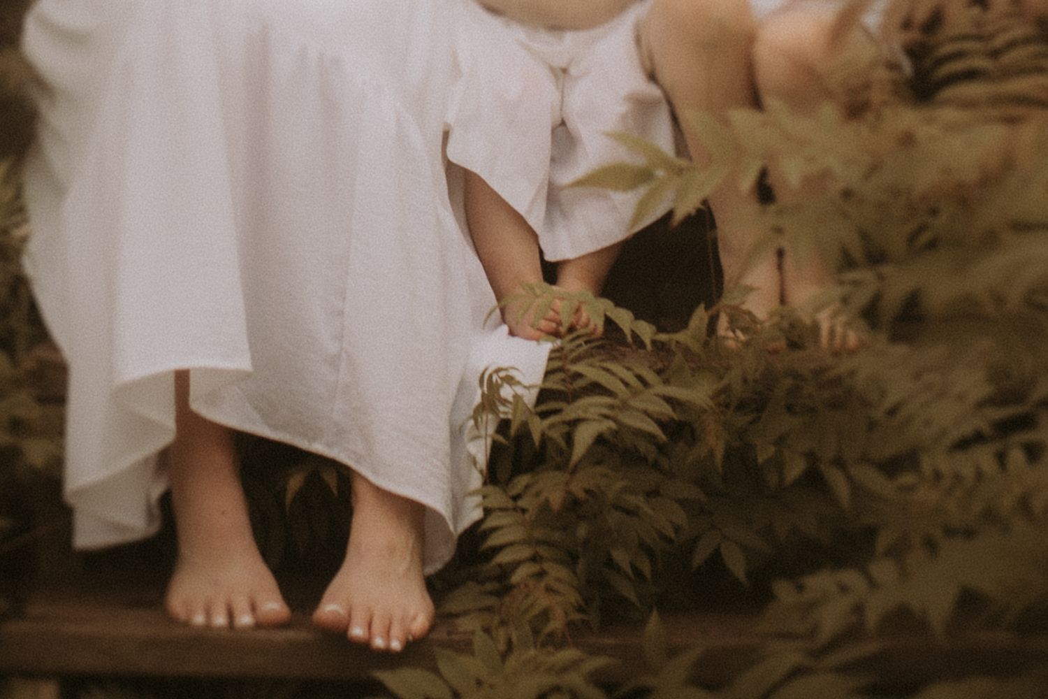 Close-up image of a mom and her children's feet on beach steps by Bowmanville maternity photographer