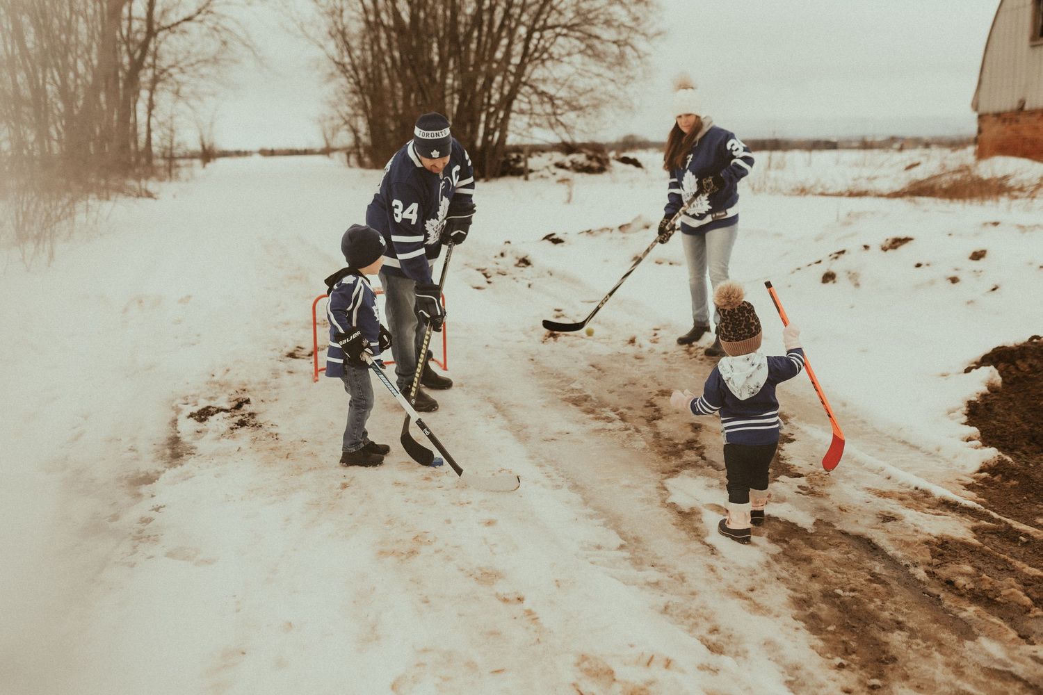 Family creating traditions and memories by playing road hockey by Newcastle, ON family photographer