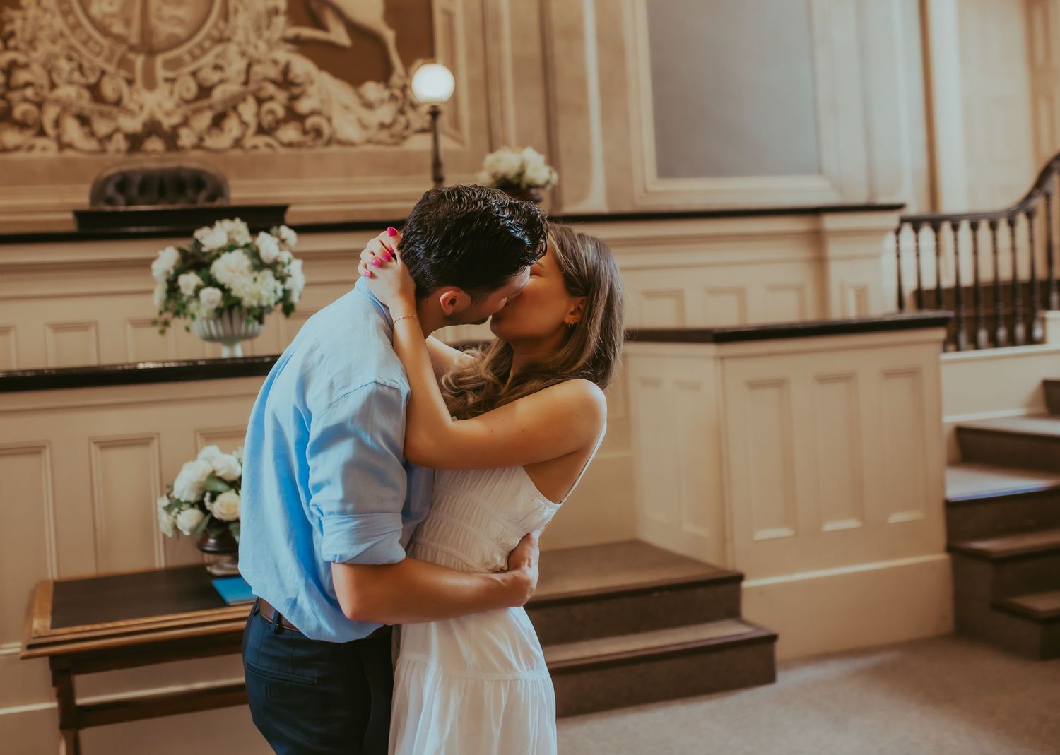 A newly married couple exchanging a kiss after their elopement ceremony inside Victoria Hall by Cobourg Elopement Photographer