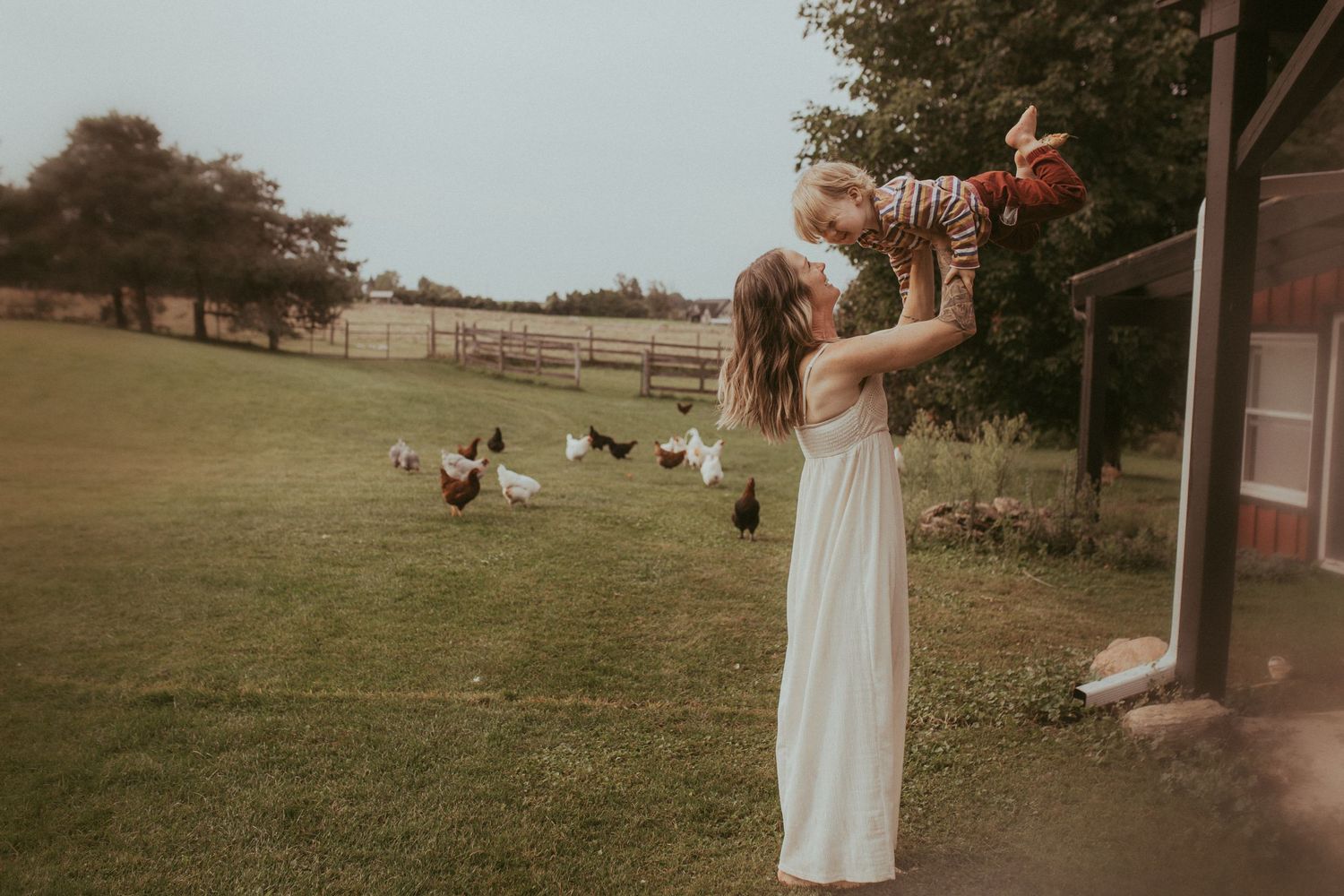 Mom playing with her son and gently tossing him in the air during a Durham Region family lifestyle photography shoot.