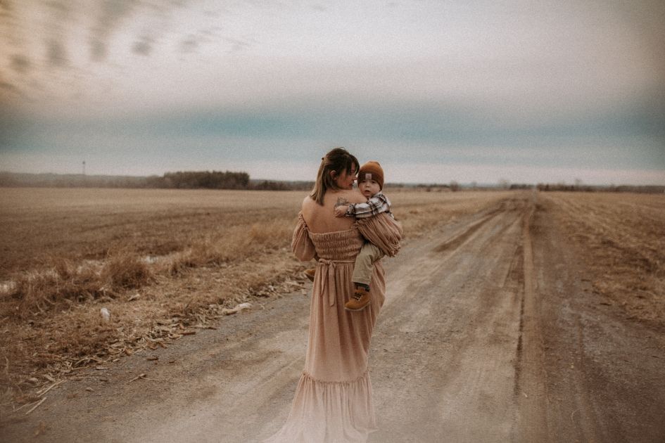 Mom walking with her child on a windswept country road in Bowmanville, ON.