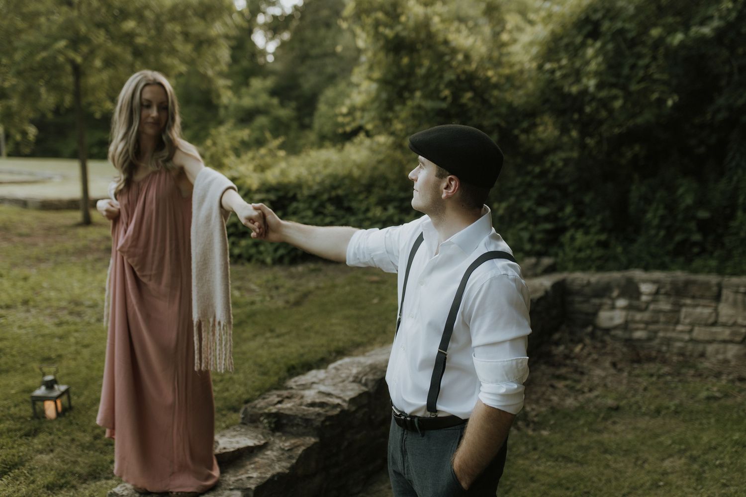 Hamilton couple walking together along an old stone wall by natural wedding photographer Bowmanville