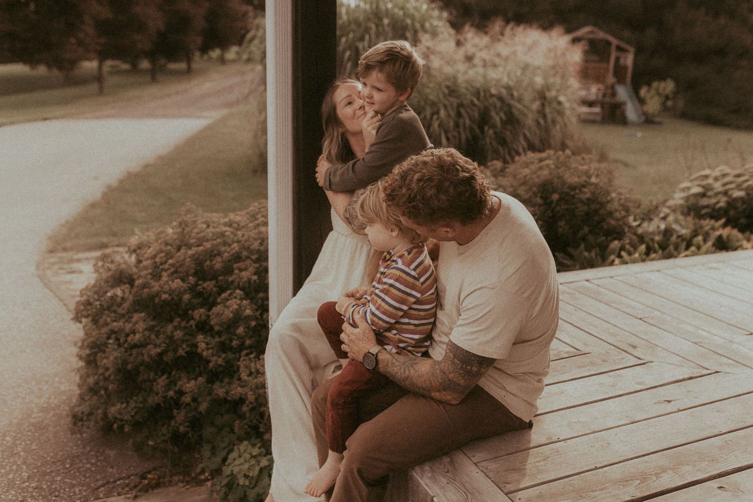 A family sits together on their front porch during a Durham Region family lifestyle photography session.
